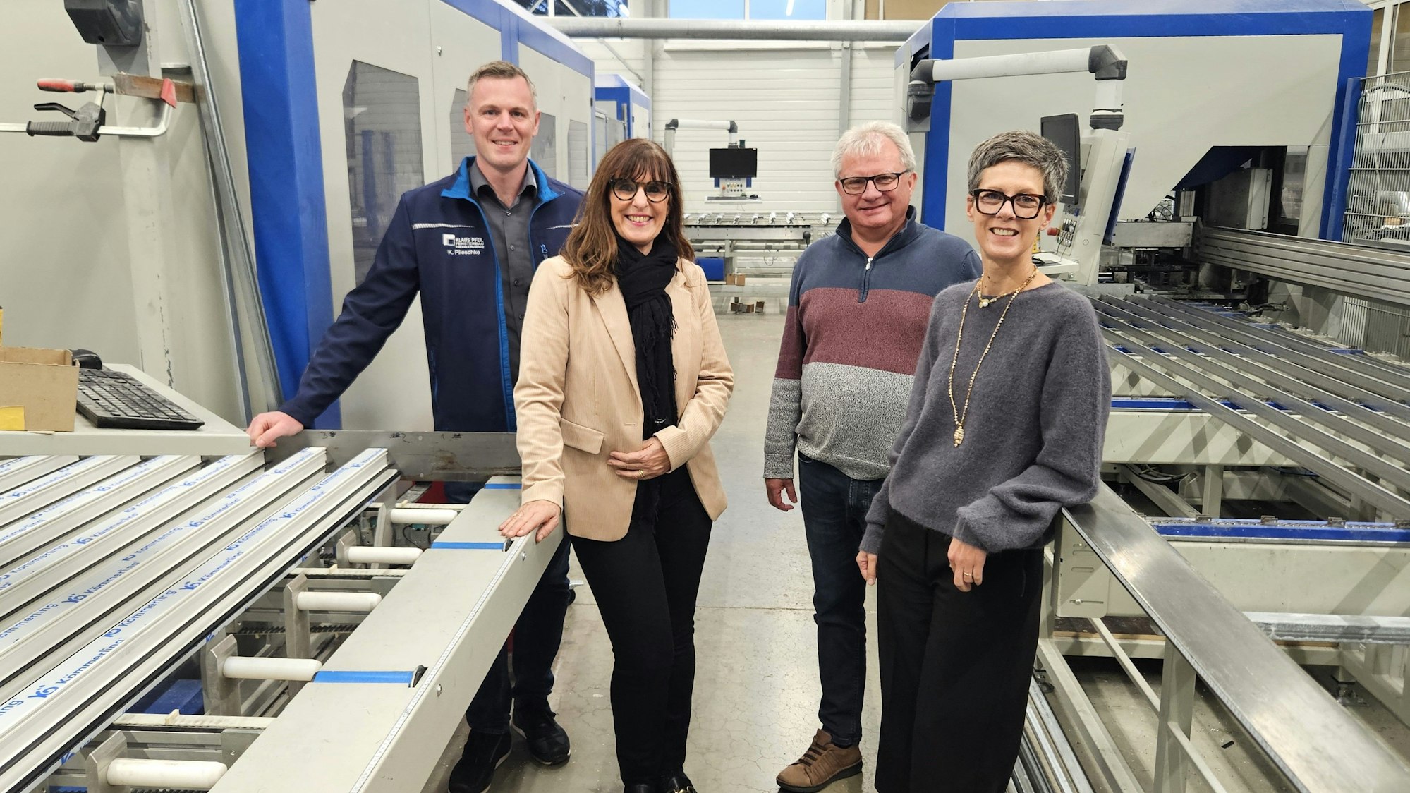Kay Plieschke (Technischer Leiter), Petra Schumacher-Hendus, Klaus Pfeil und Bianka Renn stehen zwischen zwei Maschinen.