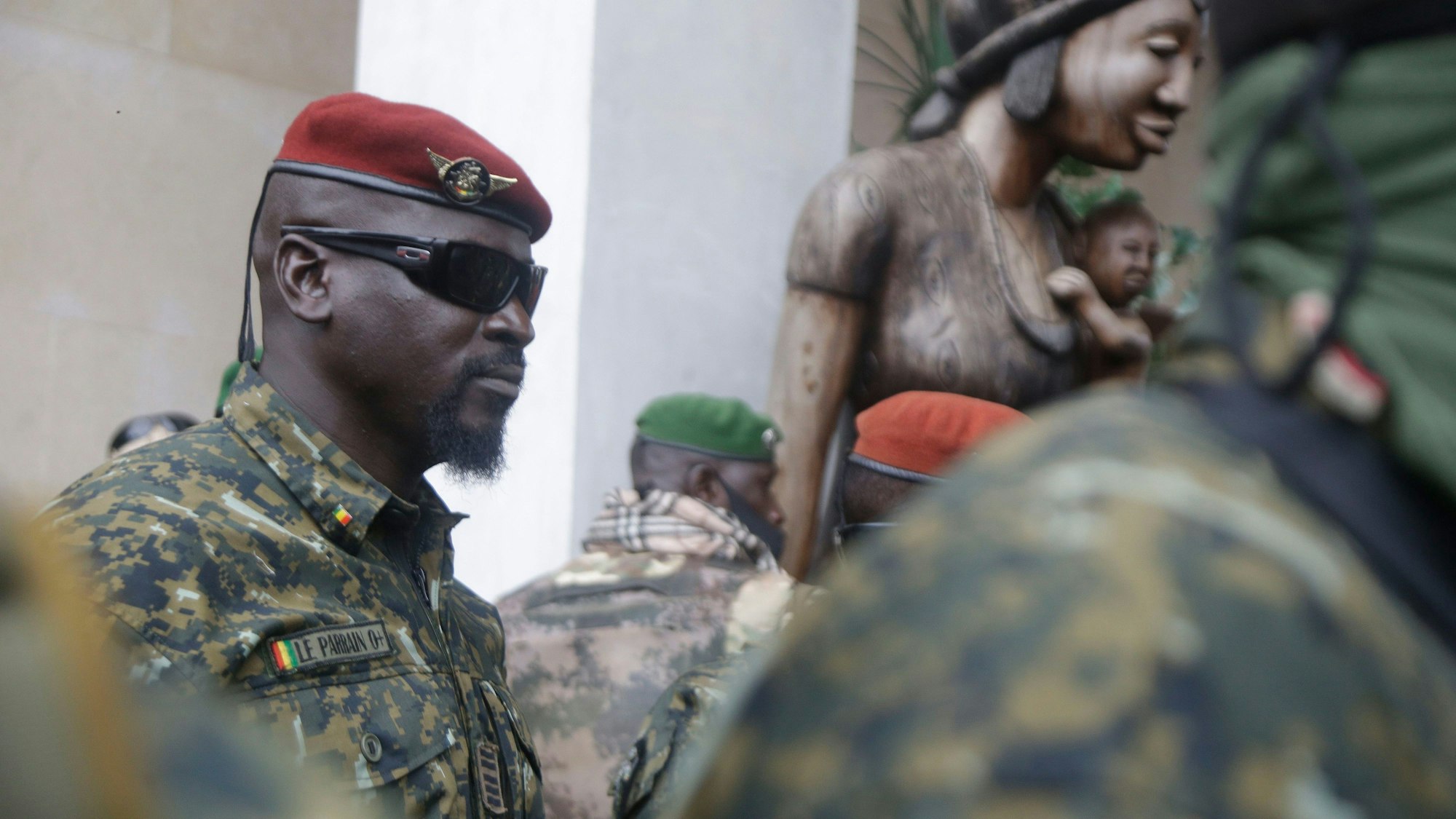 Oberst Mamady Doumbouya, damals Kommandeur der Spezialeinheit der Armee, trägt eine rote Baskenmütze und eine Sonnenbrille, während er, nach einem Treffen mit einer Delegation der Westafrikanische Wirtschaftsgemeinschaft (ECOWAS), von Soldaten umgeben ist.