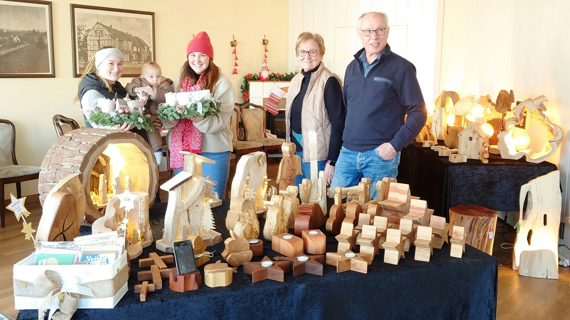Die genannten Personen zeigen Adventskränze und Holzobjekte.
