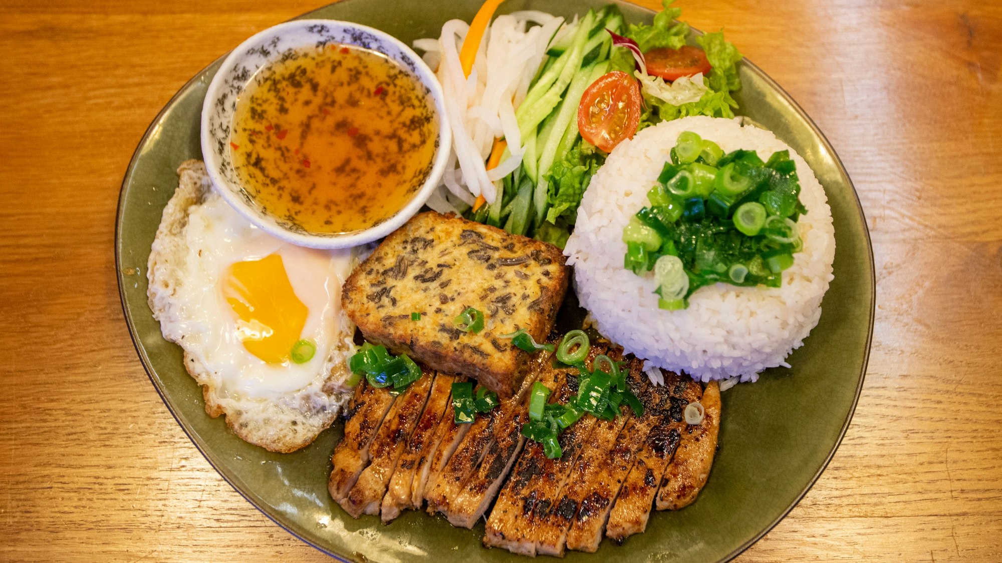 Com Tam, also gegrillten Schweinerücken, gibt es bei „District 10“ für rund 15 Euro.