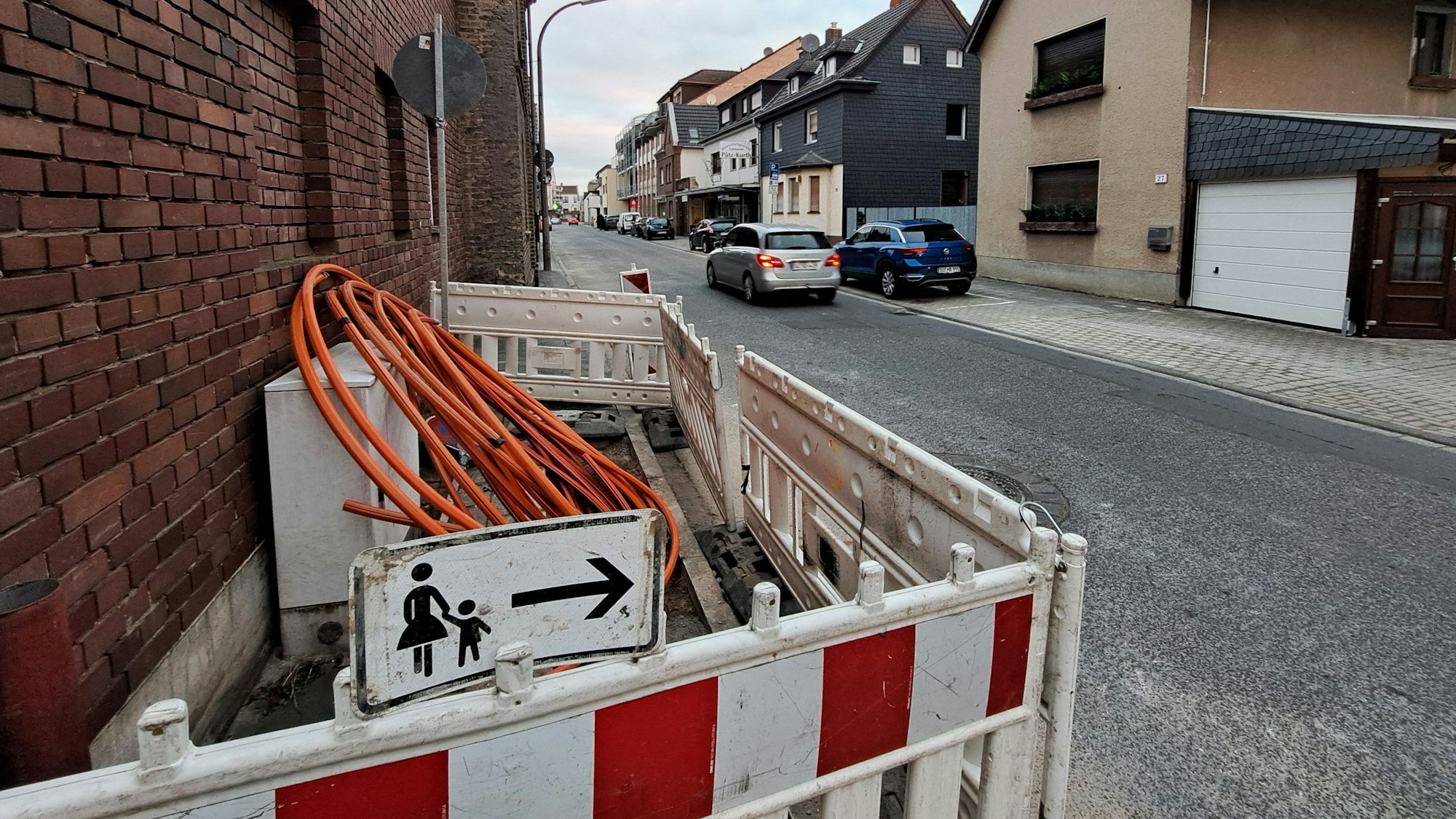 Auf einer Straße in Niederkassel-Rheidt laufen die Tiefbauarbeiten zur Verlegung des Glasfaserkabels der Telekom.