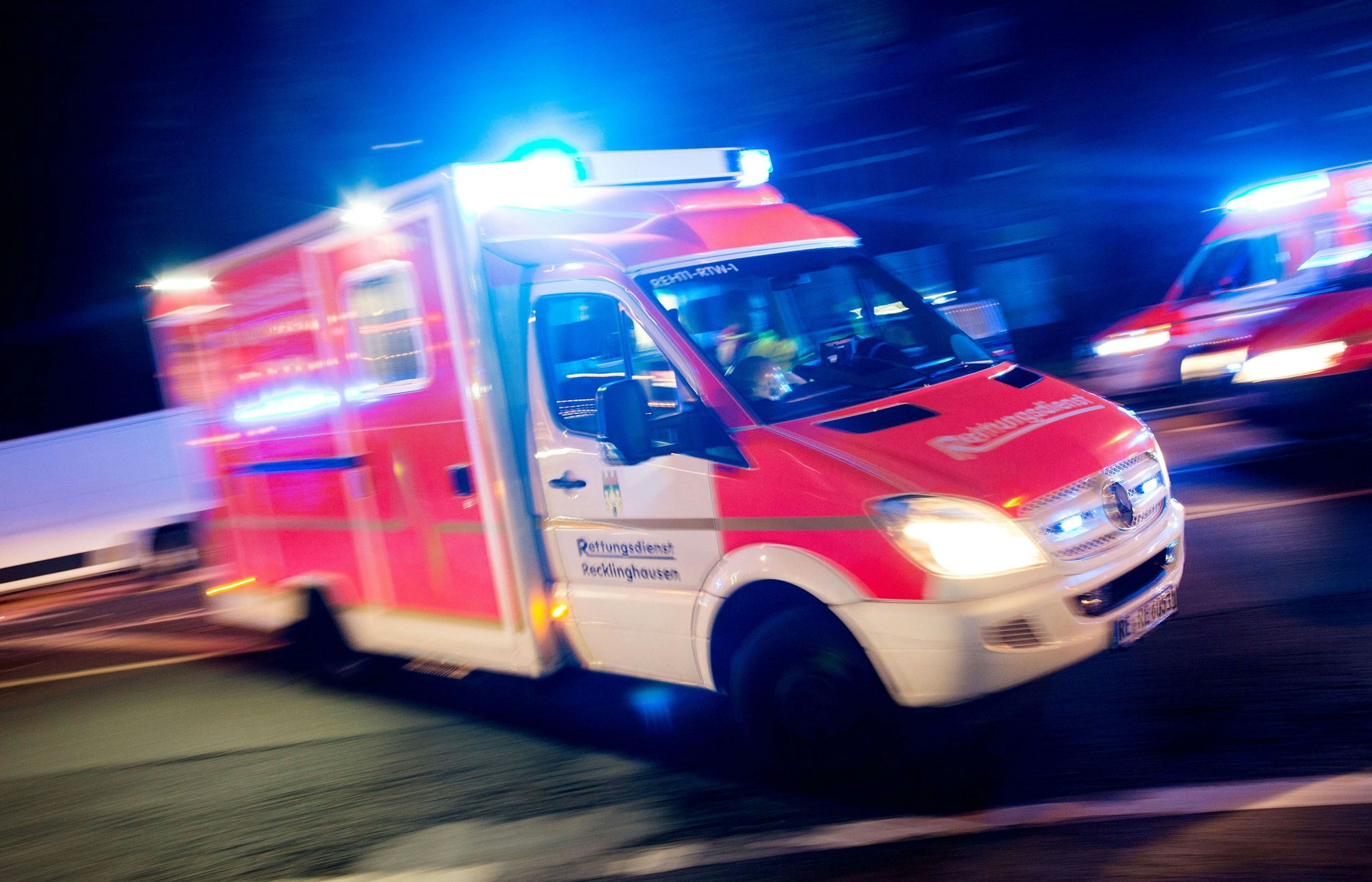Ein Rettungswagen fährt mit Blaulicht durch eine Straße.