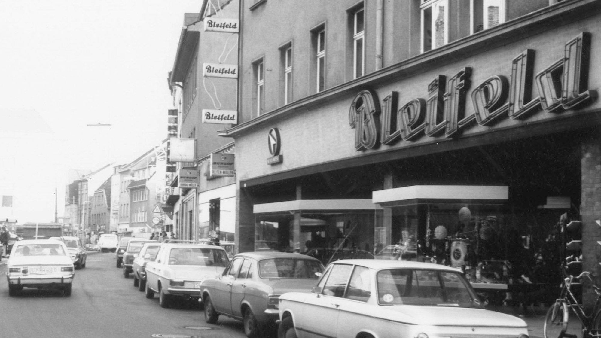 Autos parken vor einem Schuhgeschäft.