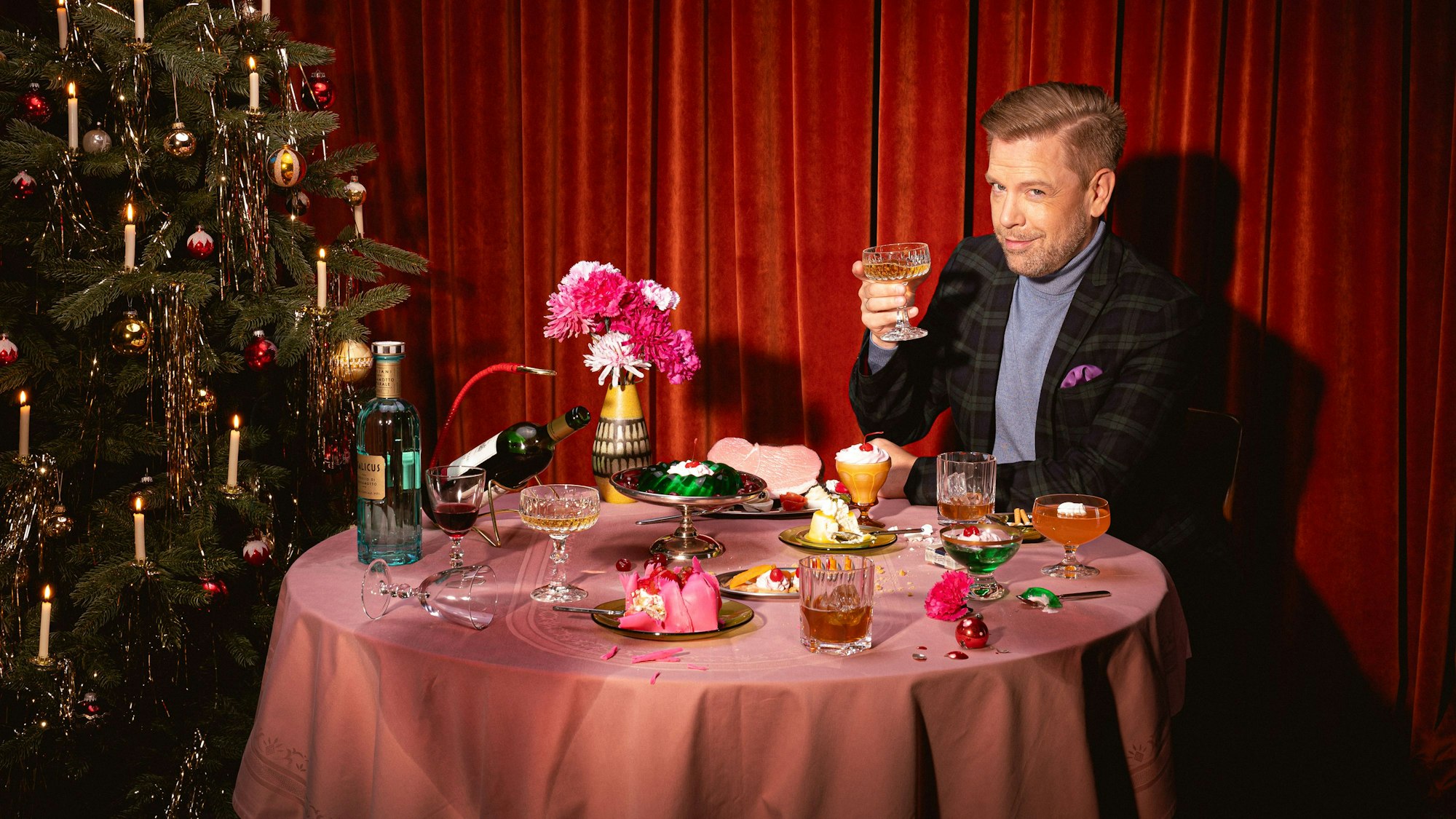 Sänger Tom Gaebel sitzt an einem weihnachtlich gedeckten Tisch.