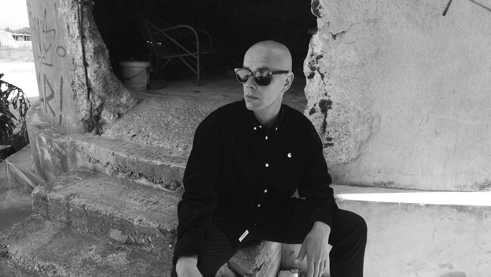 Trettmann sitzt auf einer Treppe aus Beton