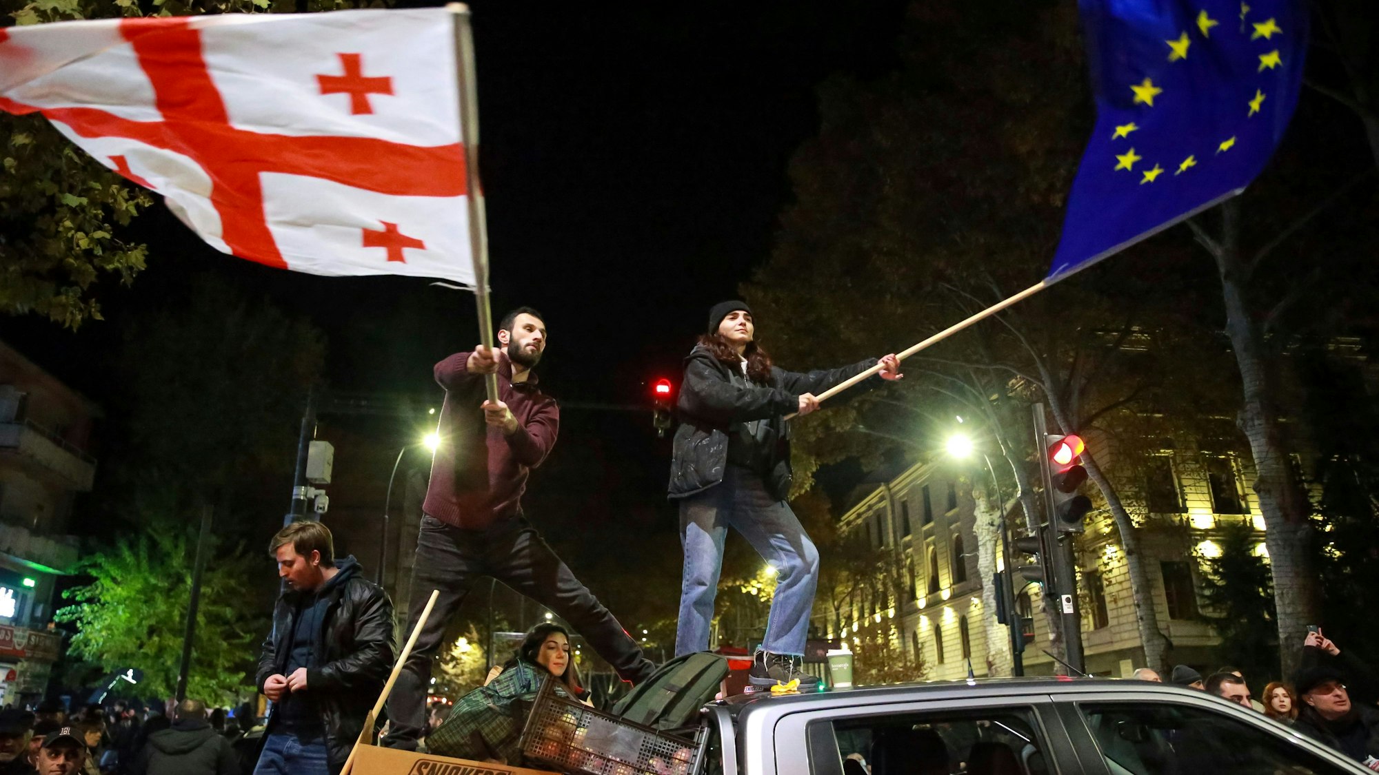 Während einer Kundgebung schwenken Demonstrierende die Flaggen der EU und Georgiens. (Archivbild vom 17.11.2024)