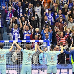 Eine Handball-Mannschaft jubelt mit ihren Fans.