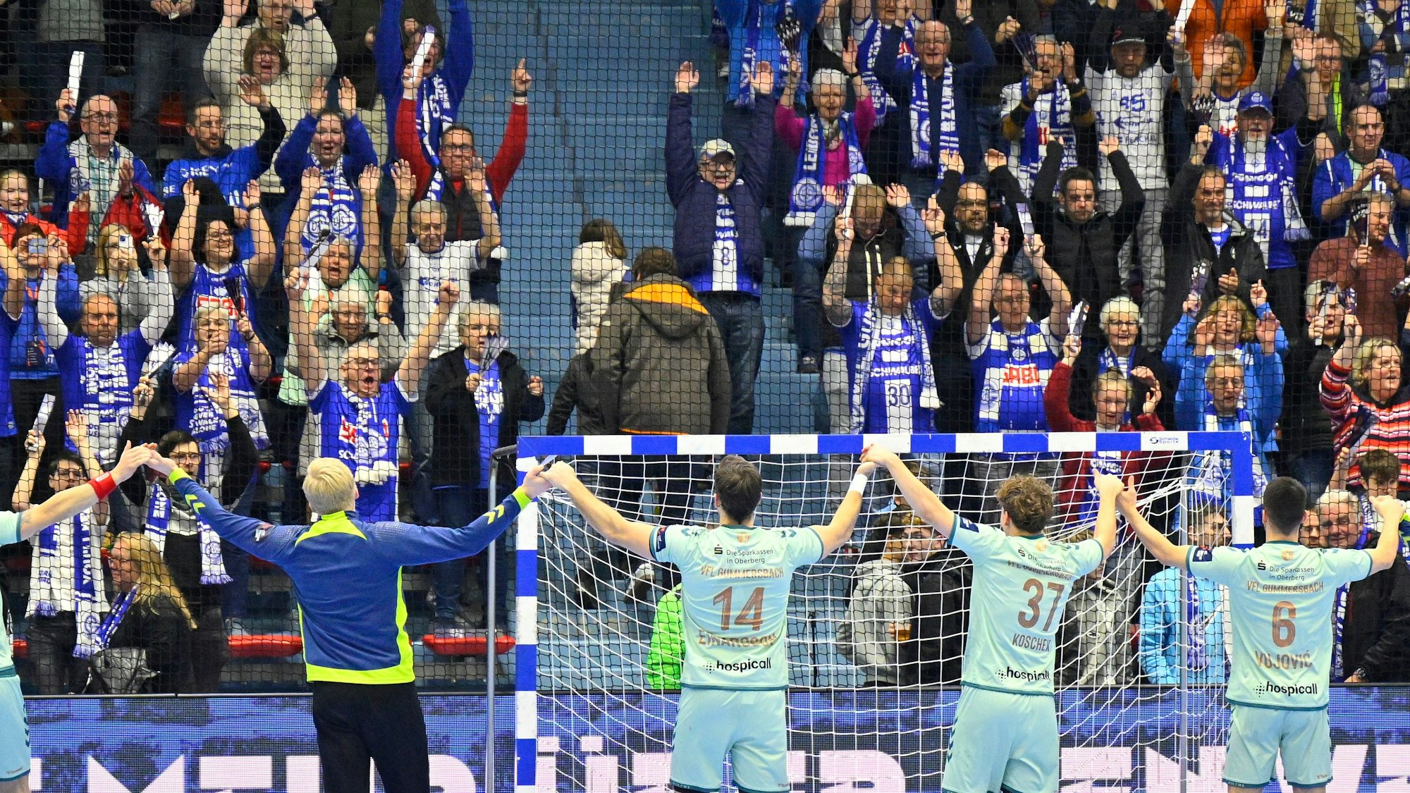 Eine Handball-Mannschaft jubelt mit ihren Fans.