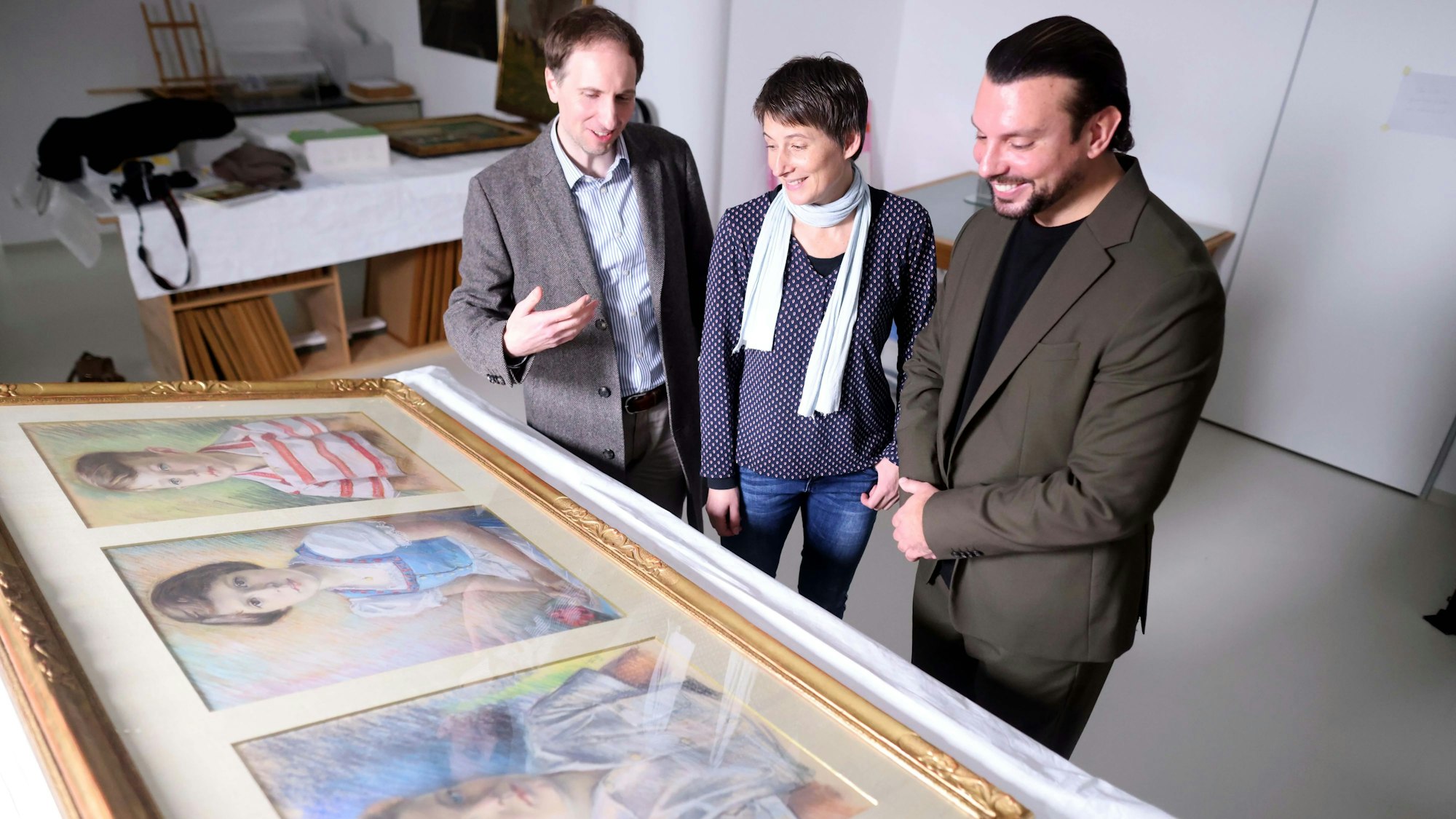 Volker Hille, Stefanie Behrendt und Marco von Reeken vor den Portraits der drei Kinder.