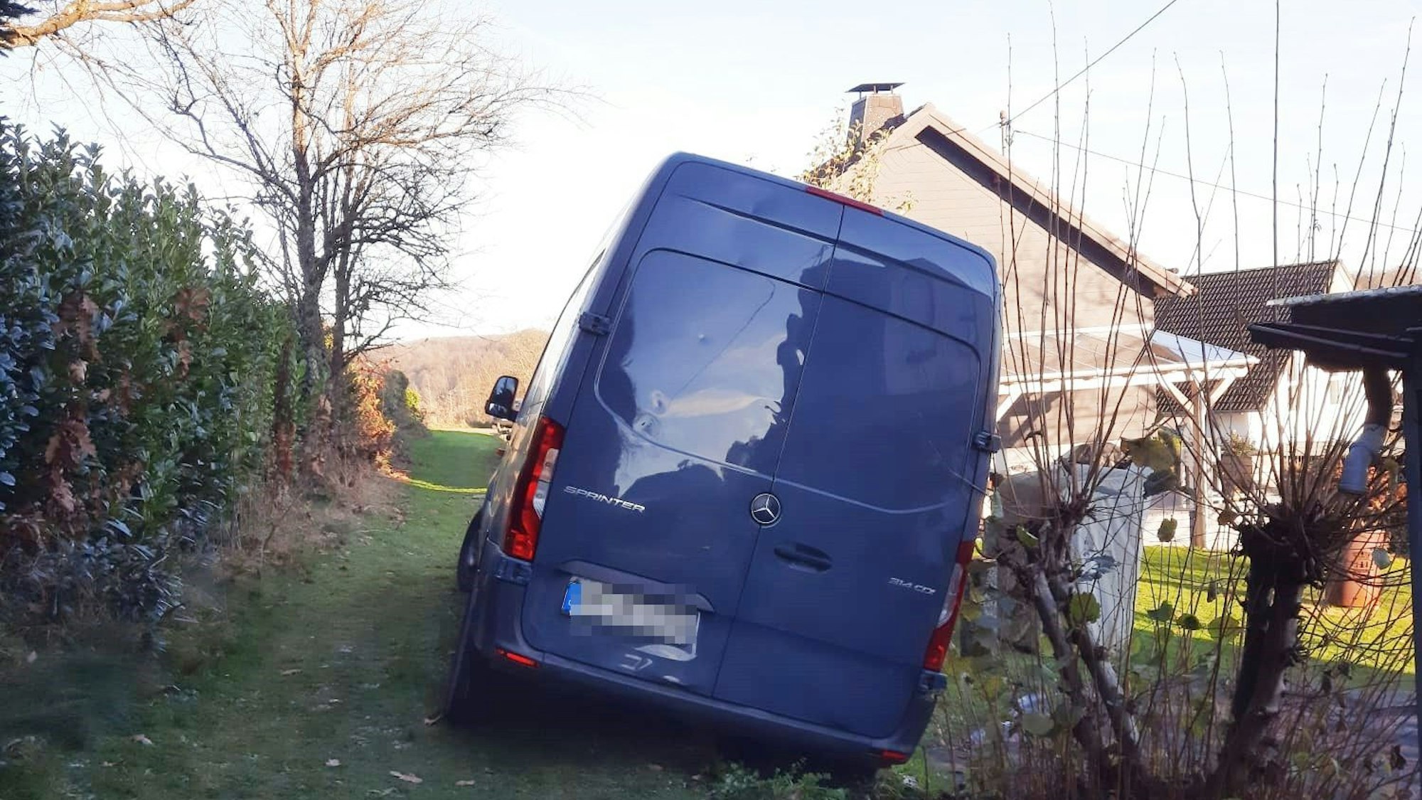 Mit der einen Seite steht der Amazon-Transporter auf einer Böschung und damit auf Boden der Stadt Waldbröl, die andere Seite des Fahrzeugs steckt aber in der Wiese einer Anwohnerin.