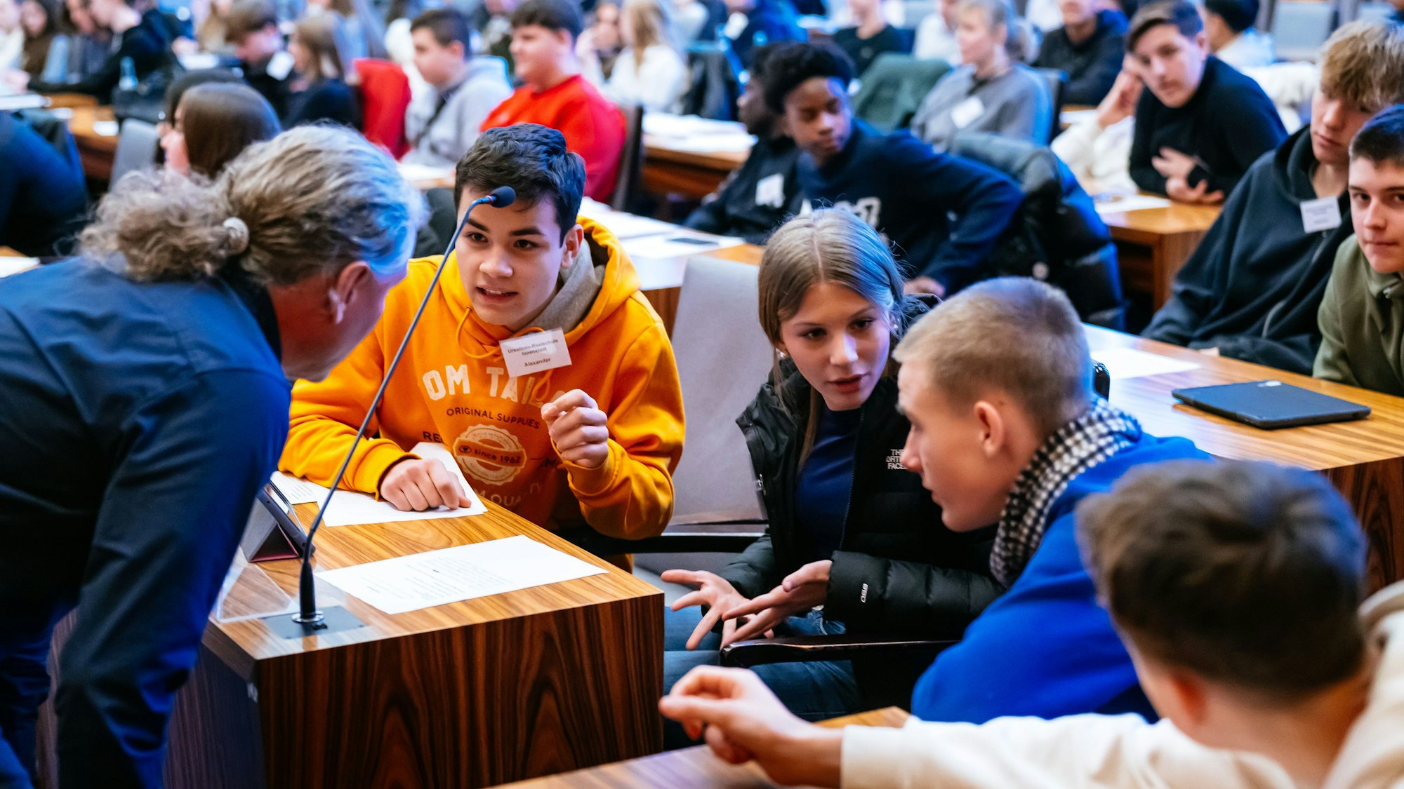 Die Jugendlichen der Ursulinenschule in den Rollen der Ratsmitglieder führen eine lebendige Diskussion.