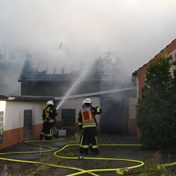 Das Foto zeigt Feuerwehrleute, die das Feuer löschen. Der Dachstuhl ist schon komplett abgebrannt.