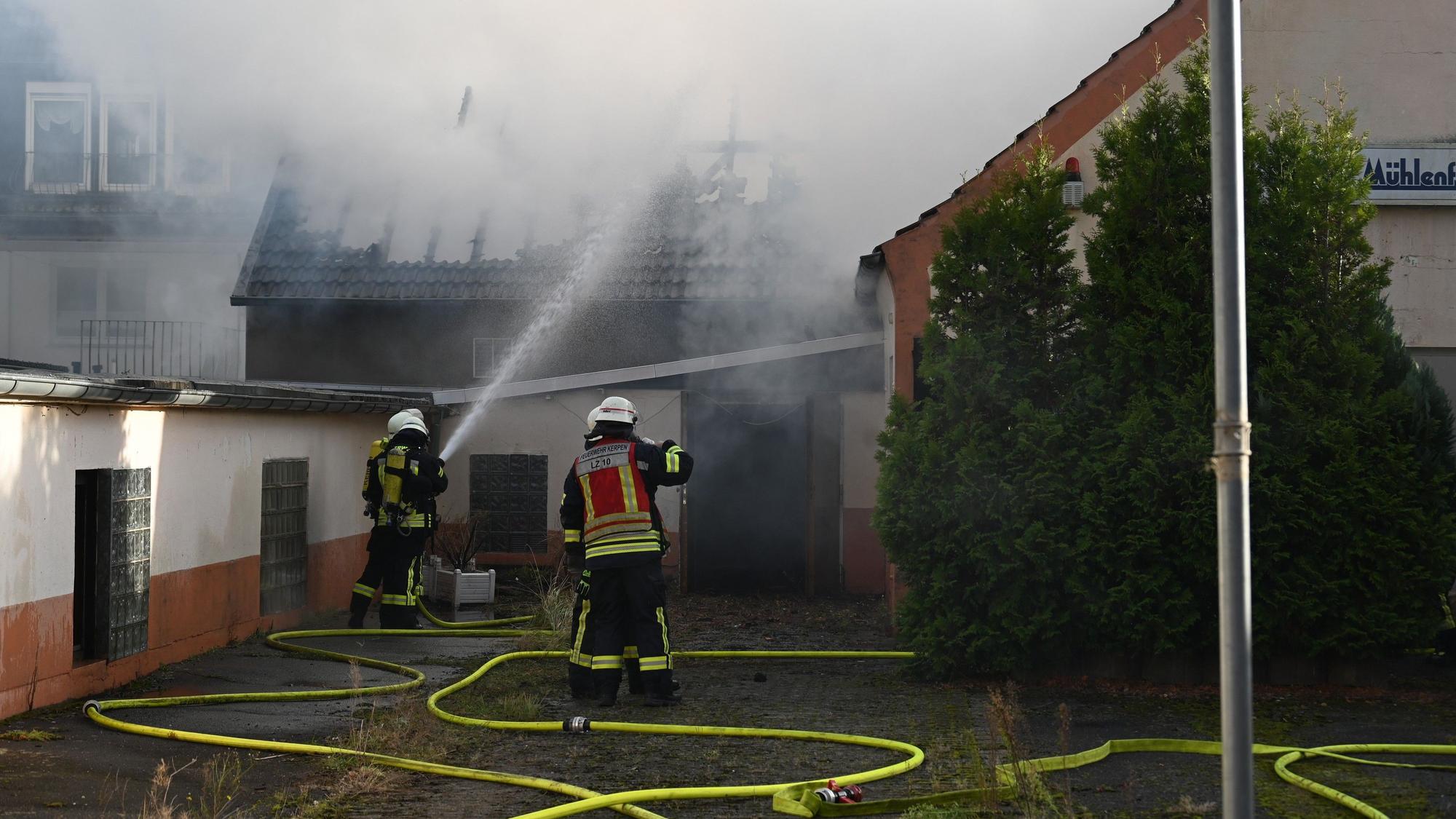Das Foto zeigt Feuerwehrleute, die das Feuer löschen. Der Dachstuhl ist schon komplett abgebrannt.