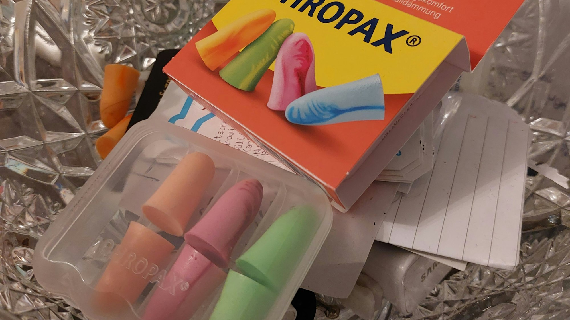 Ohropax-Ohrstöpsel in einer geschliffenen Kristallschale.