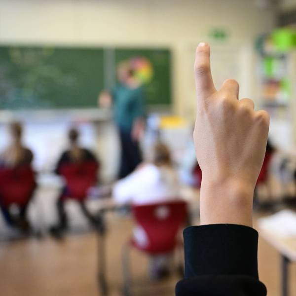Schüler melden sich in einer vierten Klasse in einer Grundschule.