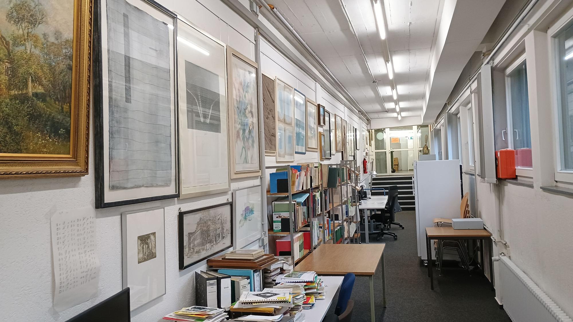 An den Wänden des Magazinbereichs im Stadtarchiv hängen viele Bilder und Gemälde.