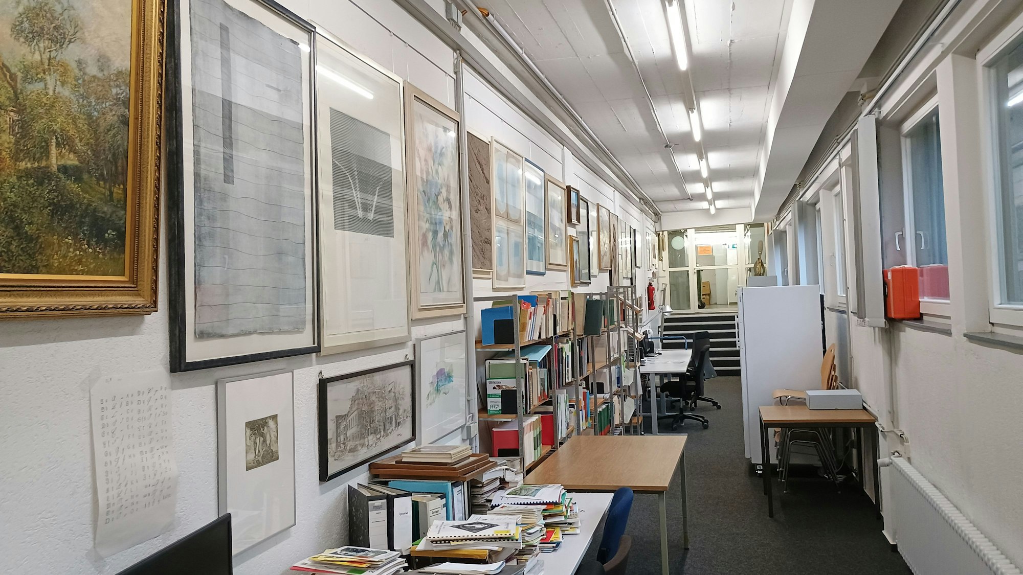 An den Wänden des Magazinbereichs im Stadtarchiv hängen viele Bilder und Gemälde.