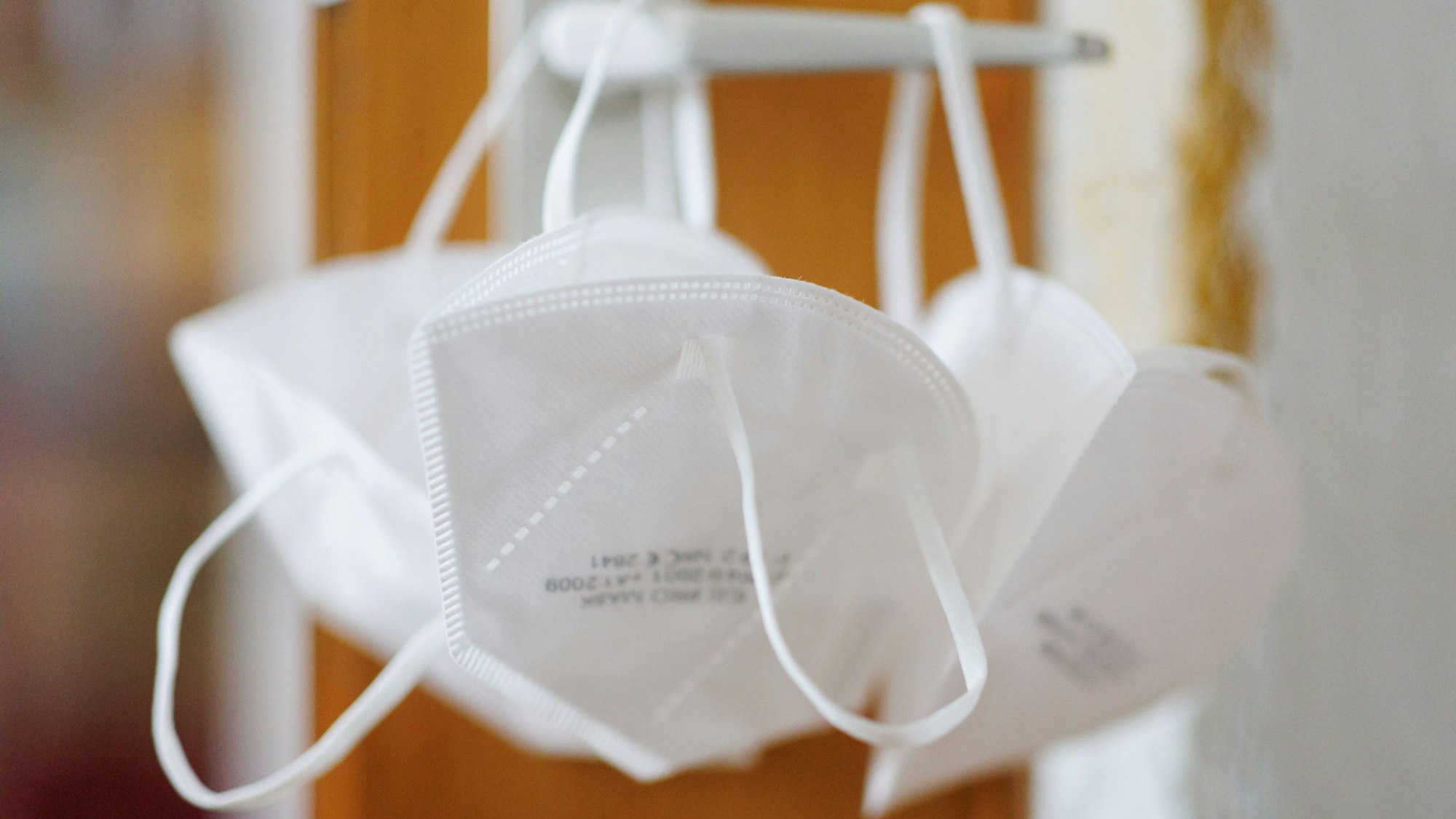 FFP2-Masken hängen an einer Türklinke.