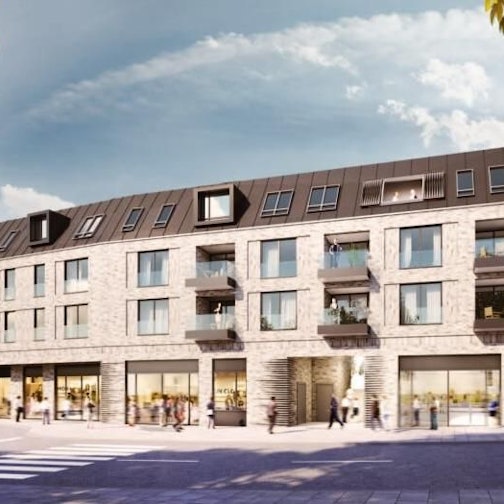 Ein Gebäude mit Geschäften im Erdgeschoss und Wohnungen in den oberen Etagen.