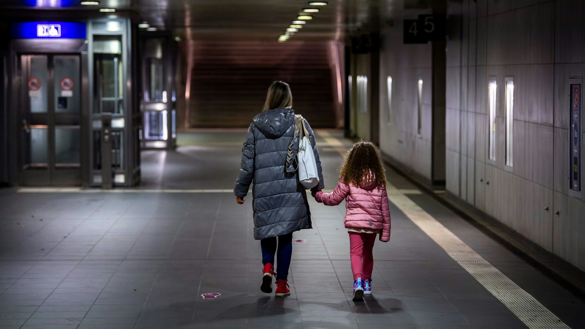 Eine Mutter geht mit ihrem Kind durch die dunkle Unterführung des Euskirchener Bahnhofs.