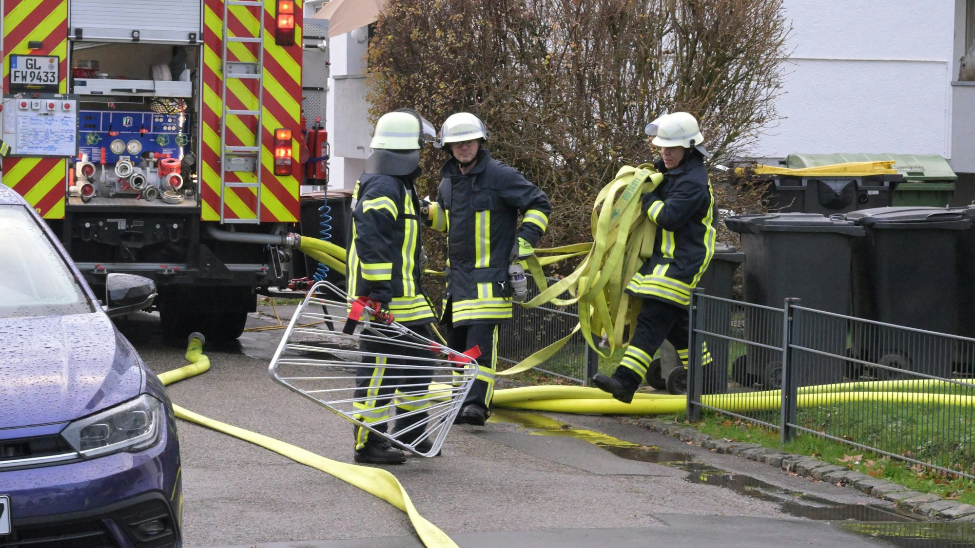 Feuerwehrleute sammeln Schläuche ein.