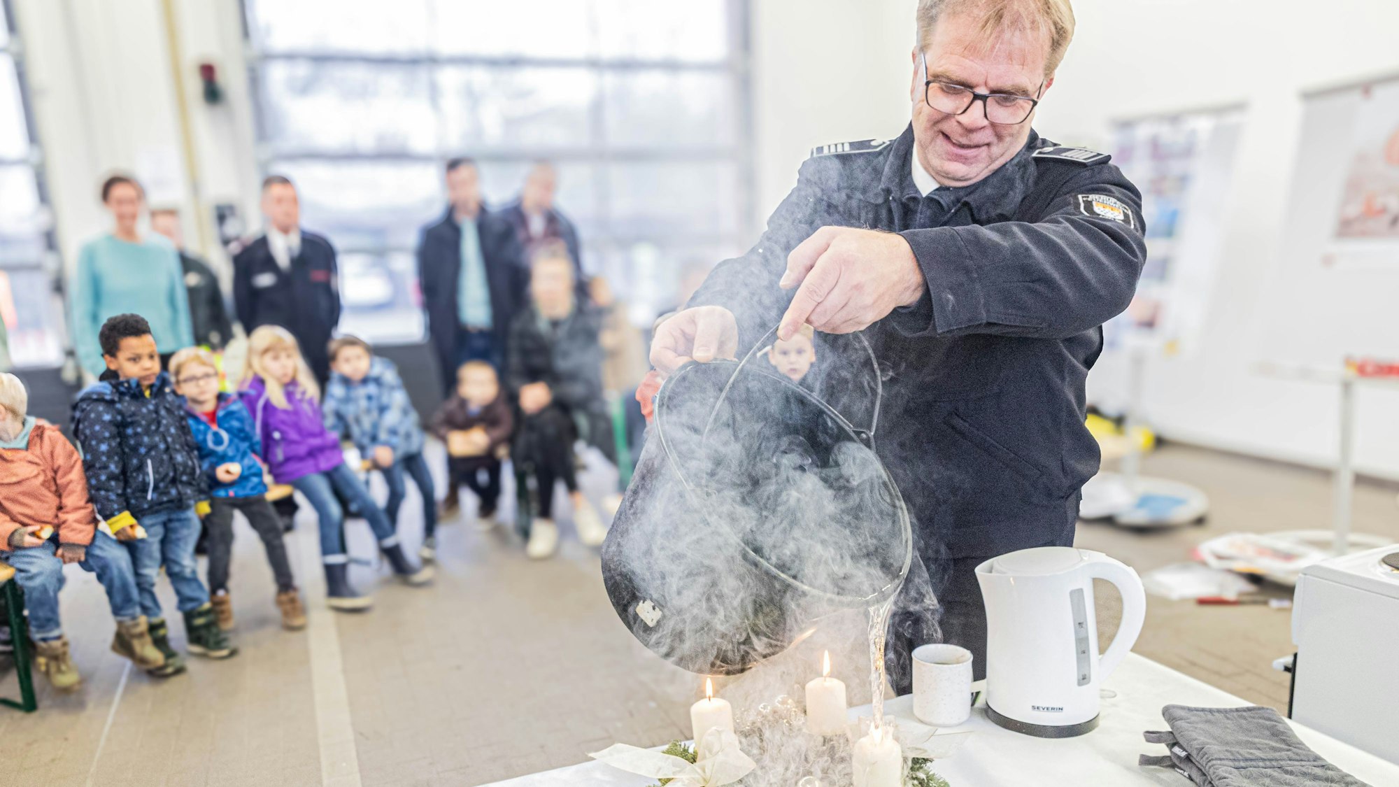 Mit einem Wassereimer wird ein brennender Adventskranz gelöscht.