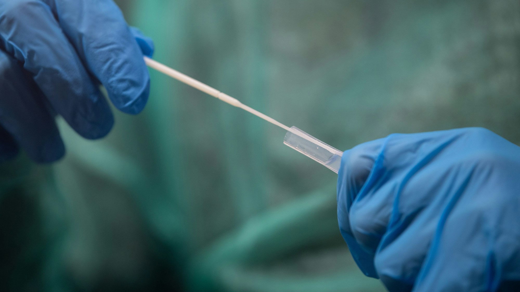 Ein Mitarbeiter führt an einer Corona-Teststelle einen Schnelltest durch.