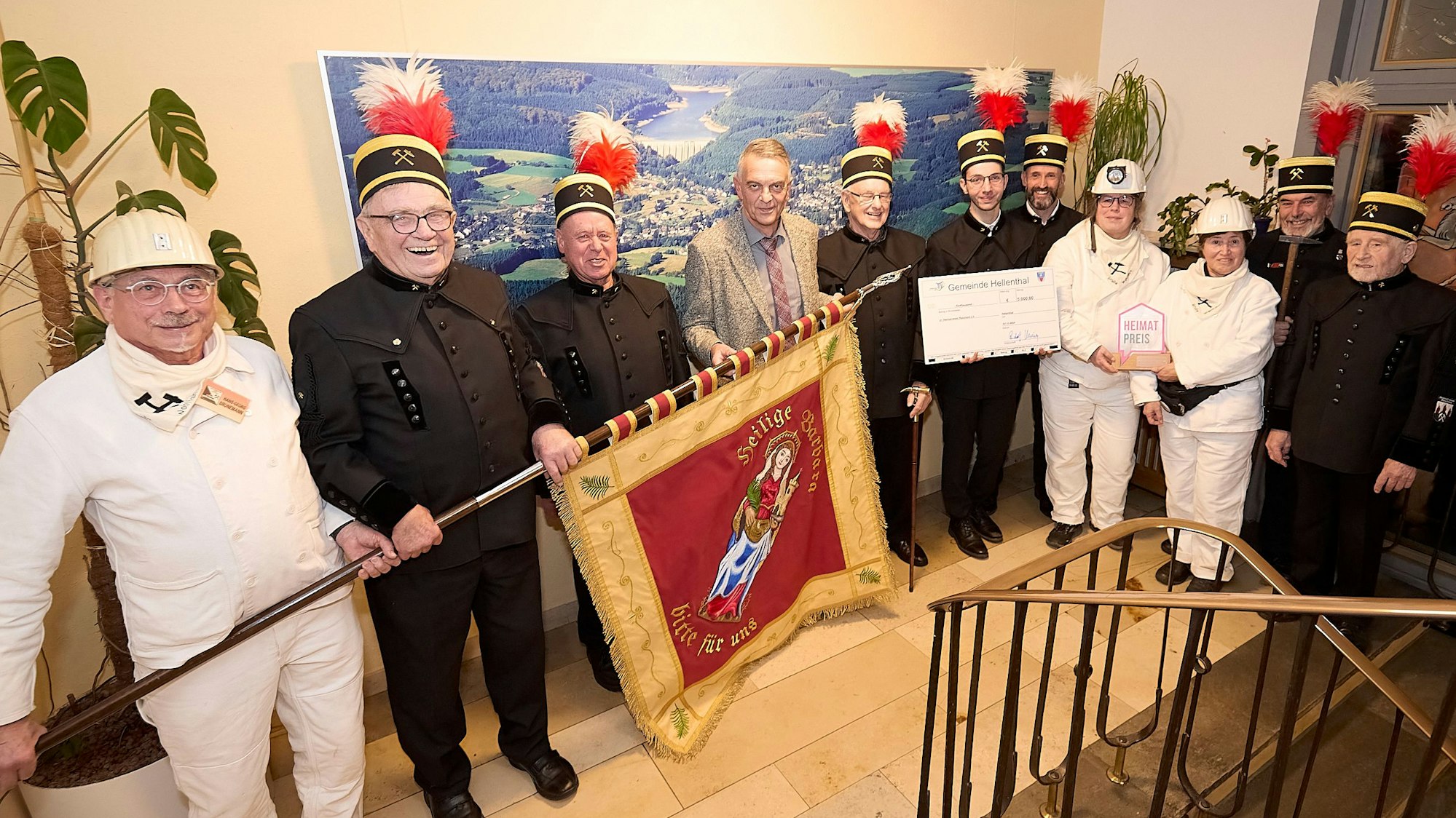 Mitglieder des Heimatvereins in Bergmannskluften haben sich mit Bürgermeister Rudolf Westerburg zu einem Foto aufgestellt.