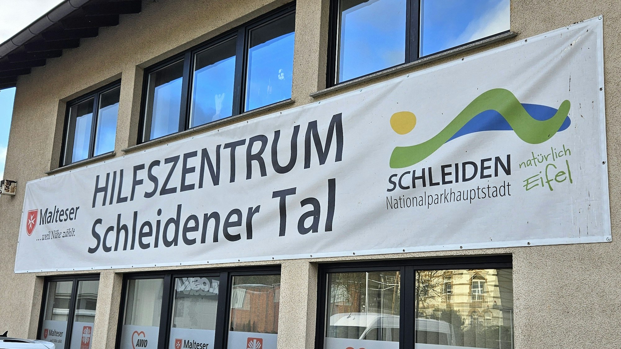 Blick auf das Hilfszentrum, an dem ein großes Transparent hängt.