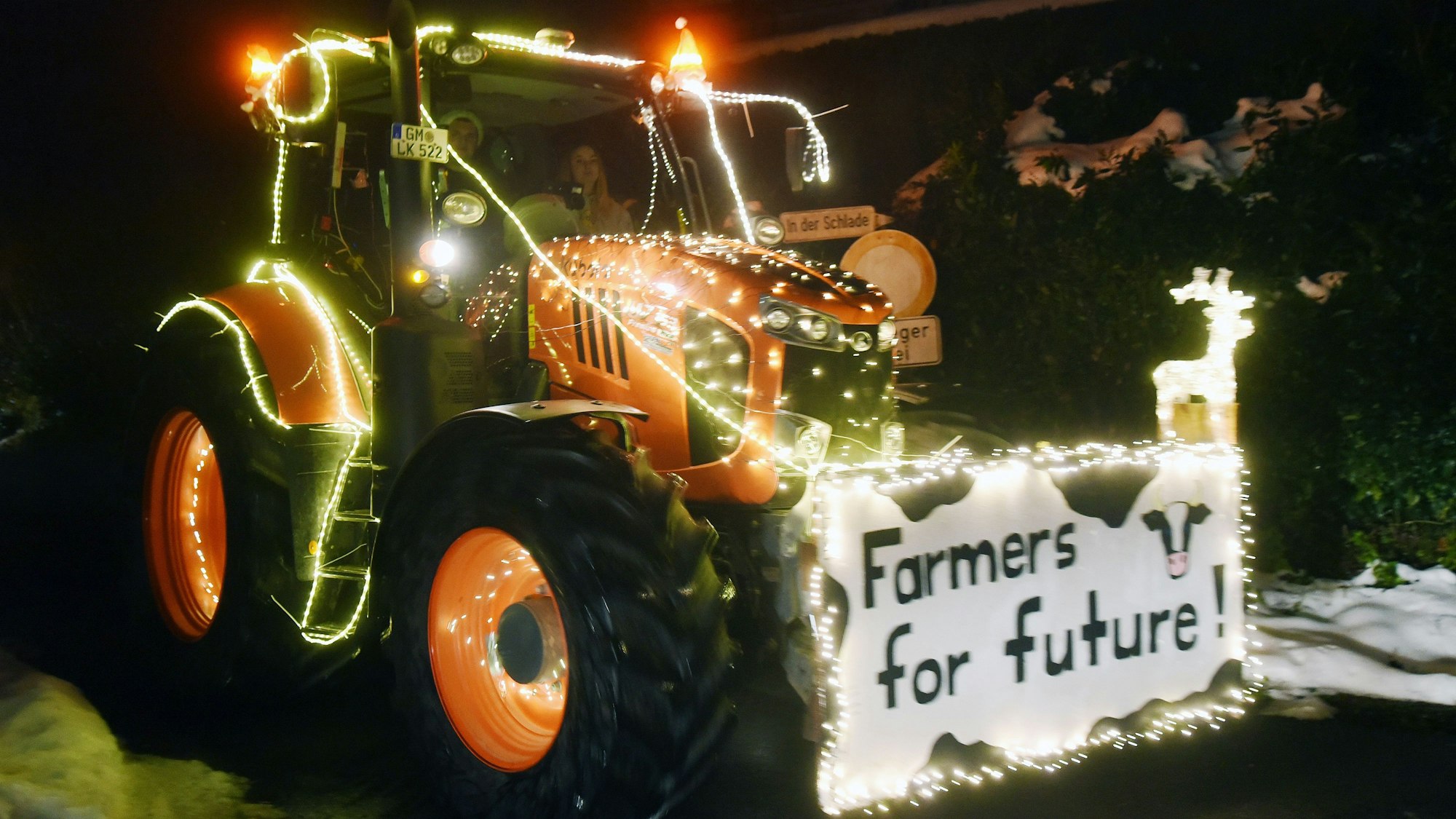 Ein mit Lichterketten geschmückter Trecker. Vorne ist ein Schild angebracht, auf dem steht: „Farmers for Future“.