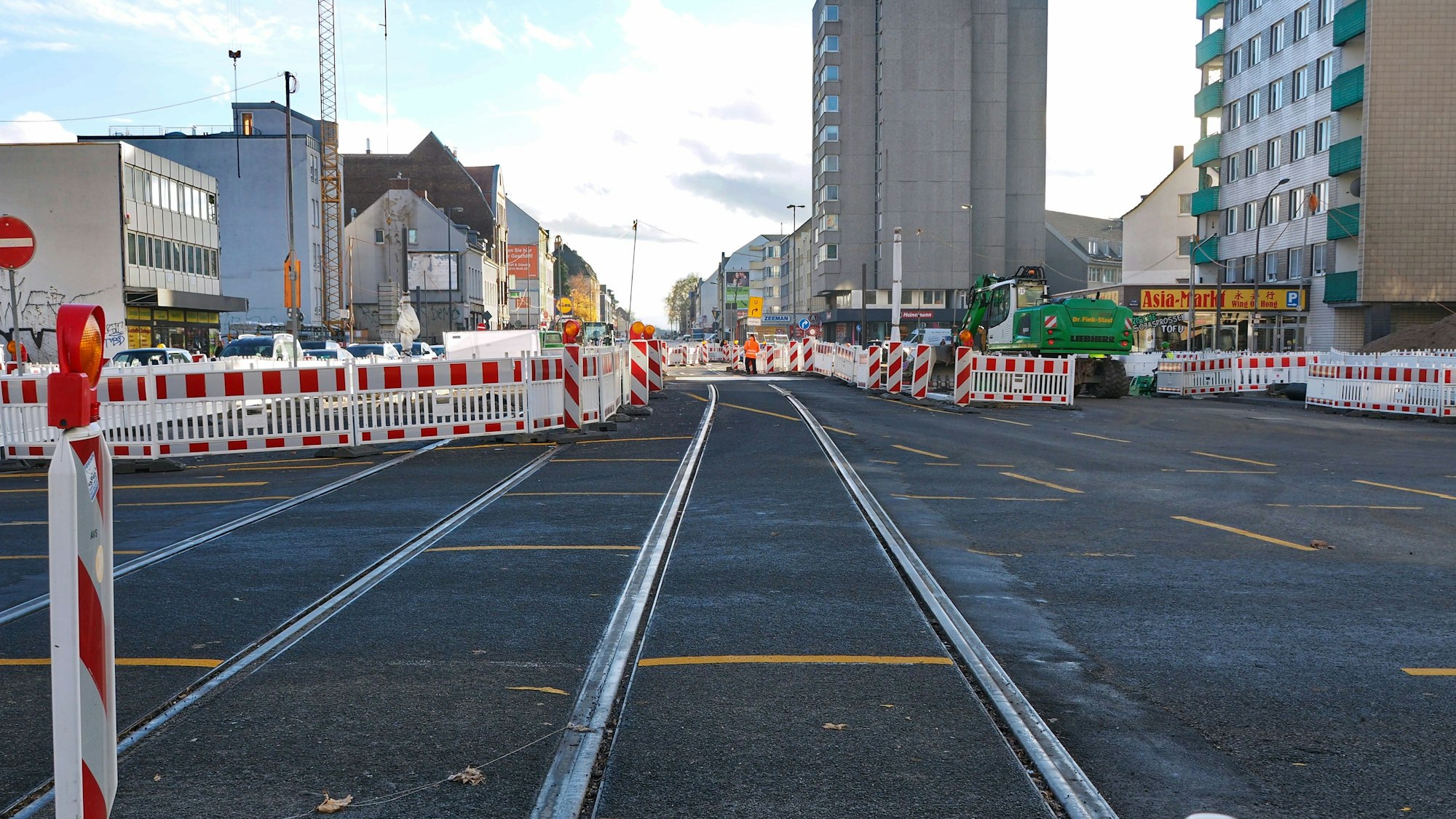 Neu verlegte Schienen an der Kreuzung Marktstraße/Bonner Straße/Schönhauser Straße. Im Hintergrund sind zahlreiche rot-weiße Bauzäune zu sehen.