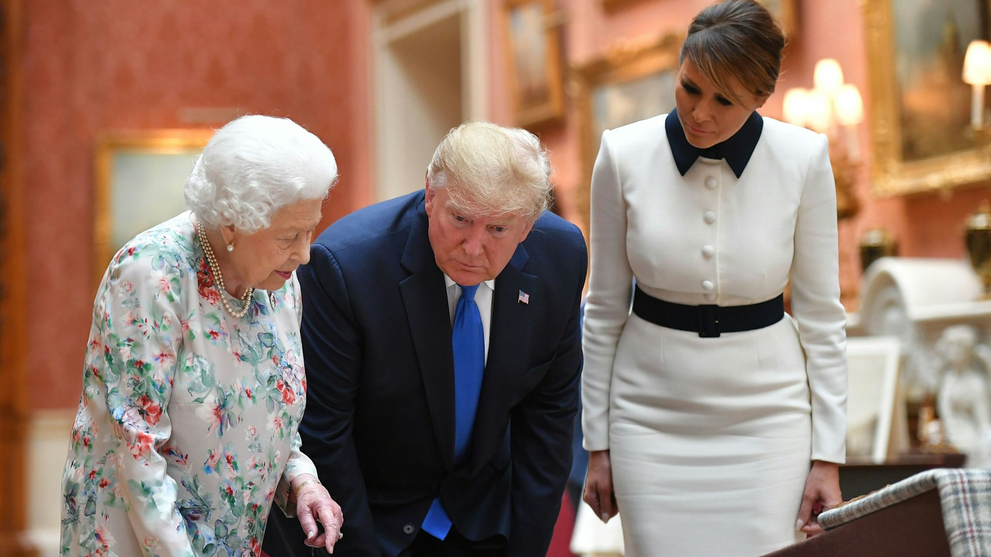 Die britische Königin Elizabeth II. (l.) betrachtet am ersten Tag ihres dreitägigen Staatsbesuchs in Großbritannien gemeinsam mit US-Präsident Donald Trump und First Lady Melania eine Ausstellung amerikanischer Objekte aus der königlichen Sammlung.