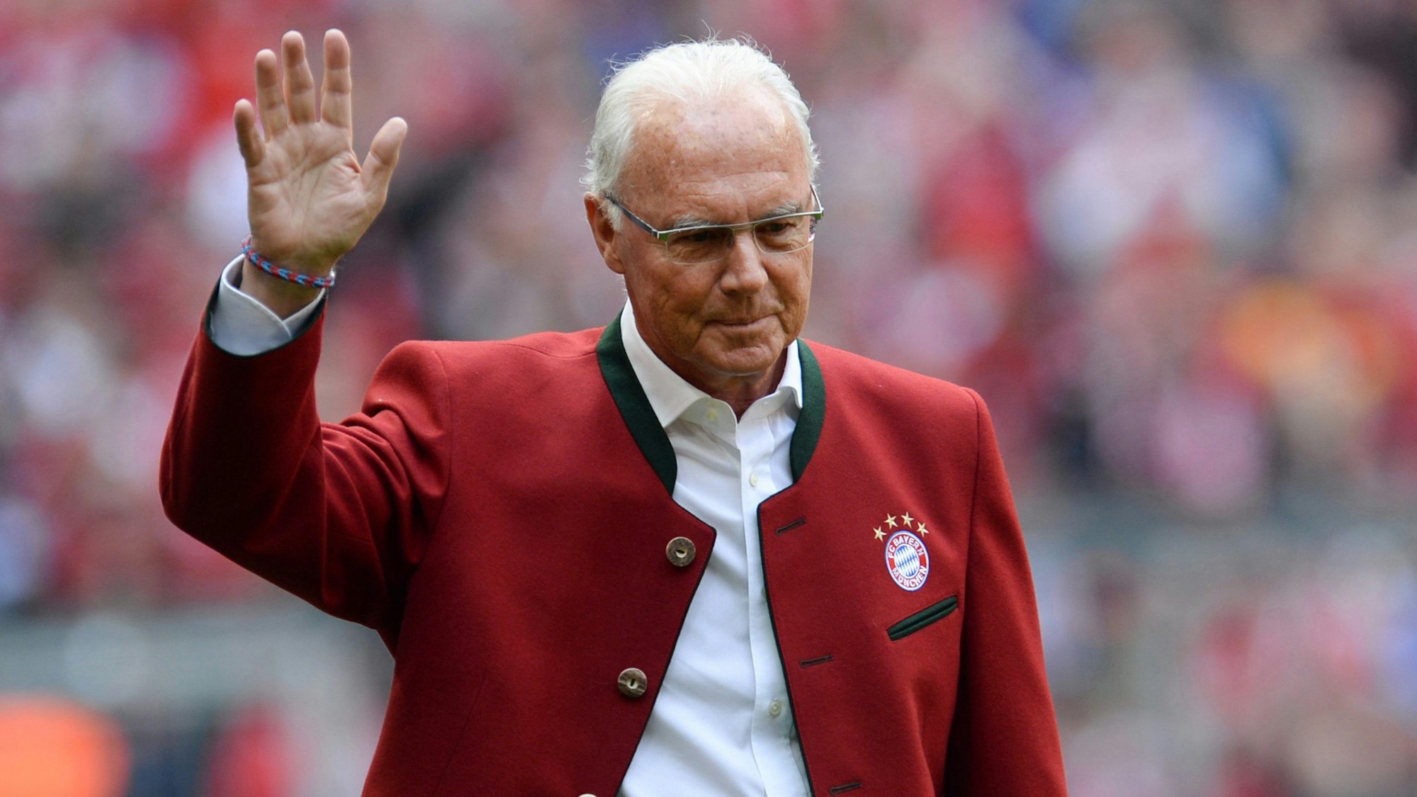 Die Anfang 2024 verstorbene FC-Bayern-Legende Franz Beckenbauer geht während der Präsentation der Meistermannschaften vor Spielbeginn zum Podium und winkt.