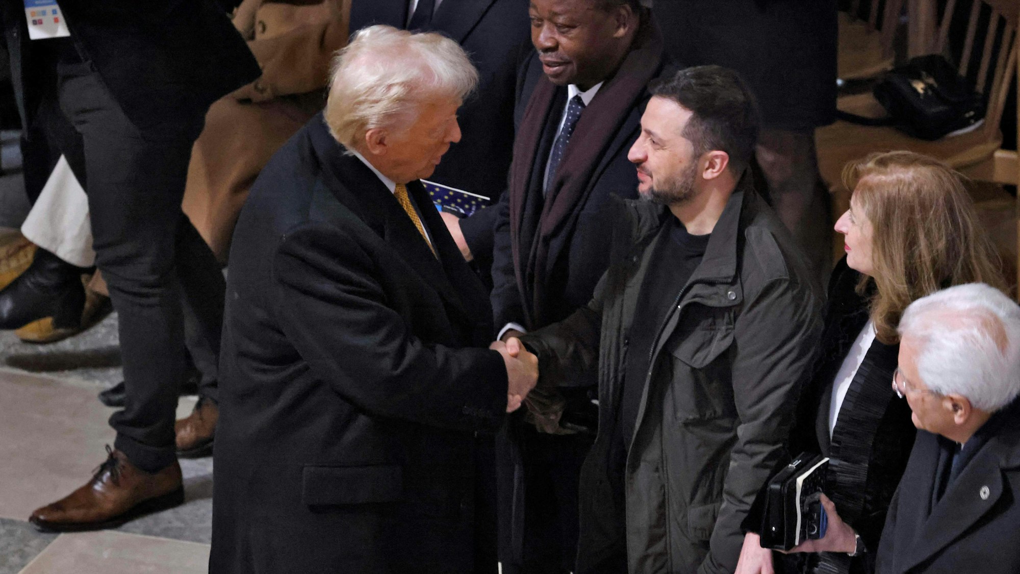 Donald Trump begrüßt Wolodymyr Selenskyj in Paris und schüttelt ihm die Hand.