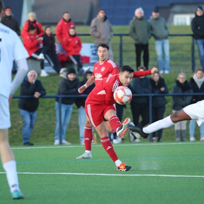Zülpichs Marlon Große schießt aus der Distanz. Ein Verteidiger versucht, ein Bein vor den Ball zu bekommen.