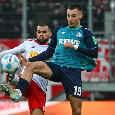 Robin Ziegele von Jahn Regensburg (l) und FC-Stürmer Tim Lemperle kämpfen um den Ball.
