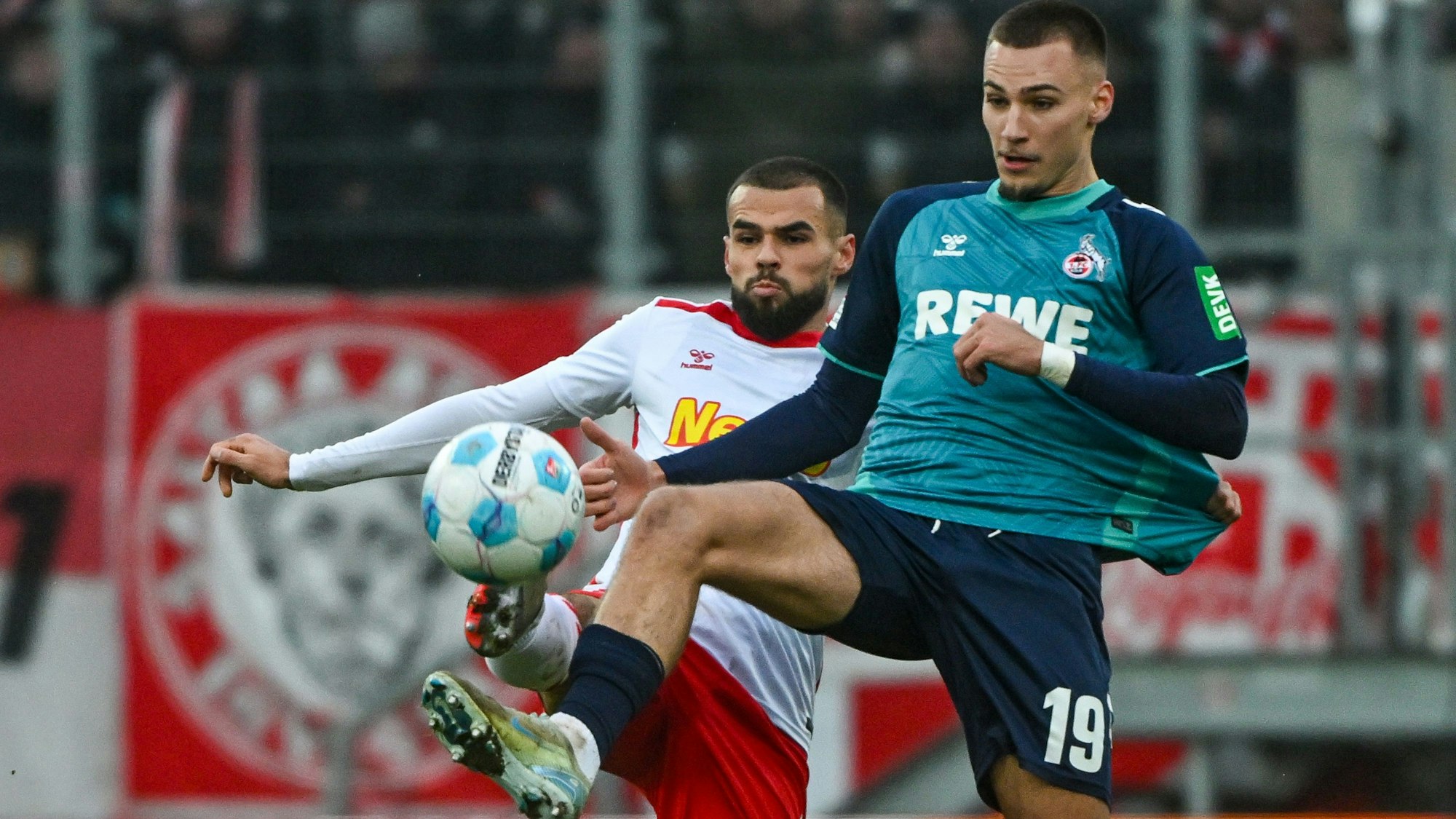 Robin Ziegele von Jahn Regensburg (l) und FC-Stürmer Tim Lemperle kämpfen um den Ball.