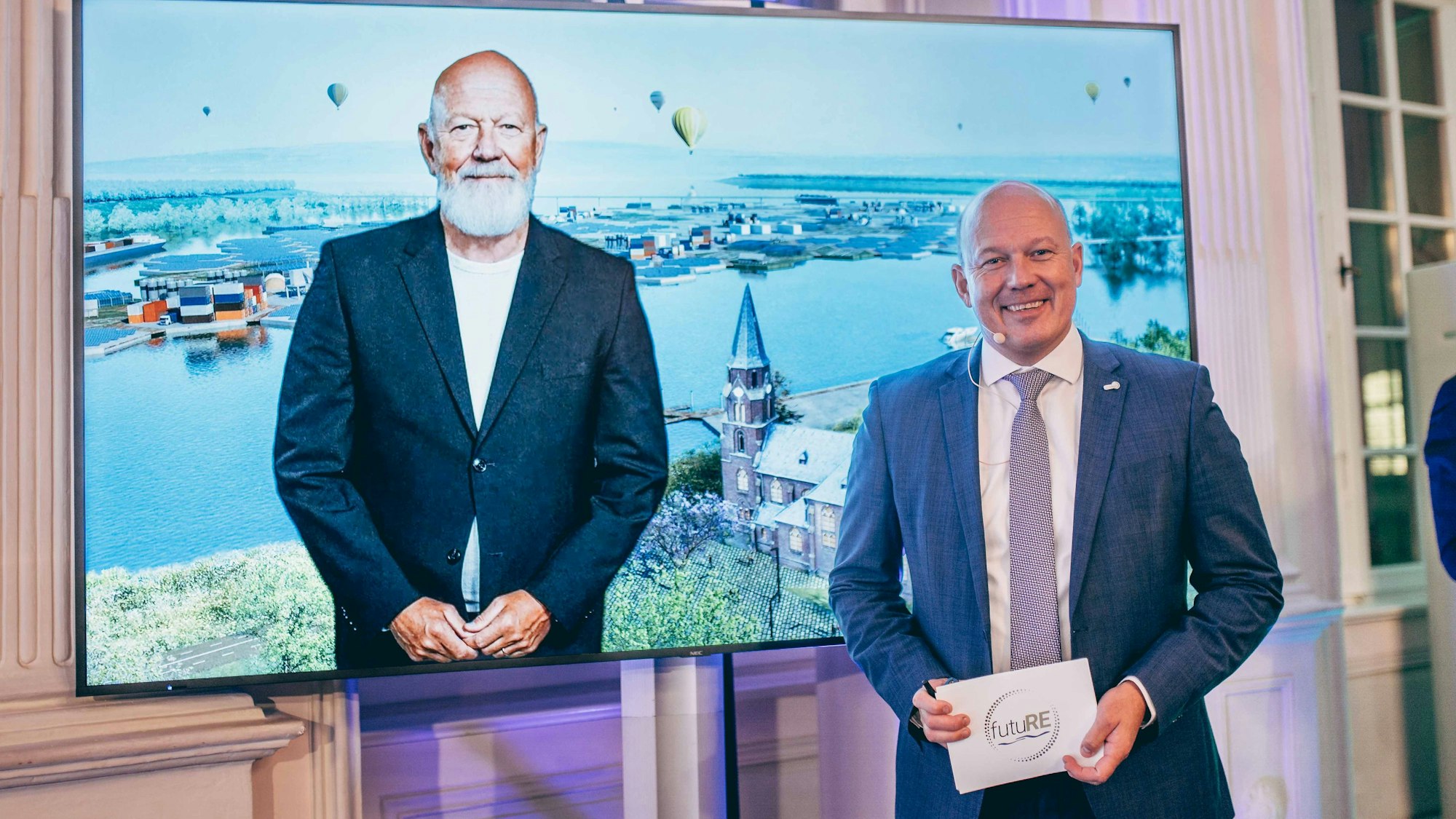 Zu sehen sind Landrat Frank Rock und sein künstlich gealtertes zweites Ich auf einem Bildschirm.