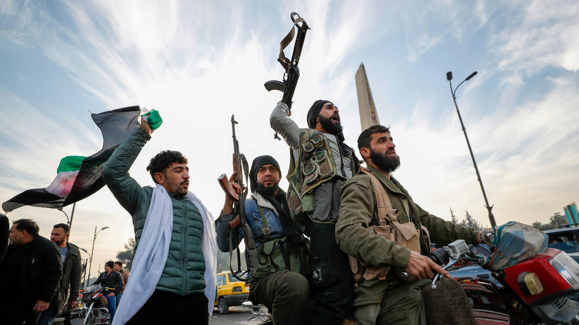 Syrische Oppositionskämpfer feiern nach dem Zusammenbruch der syrischen Regierung.