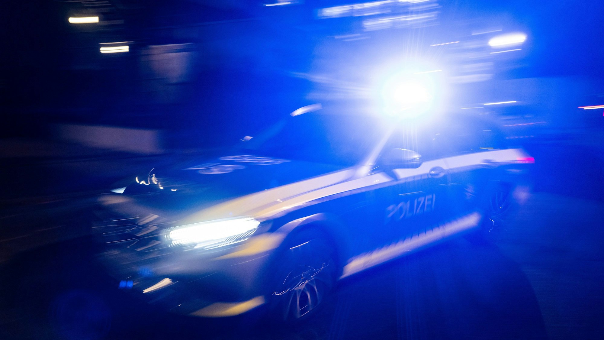 Ein Polizeifahrzeug fährt mit Blaulicht.