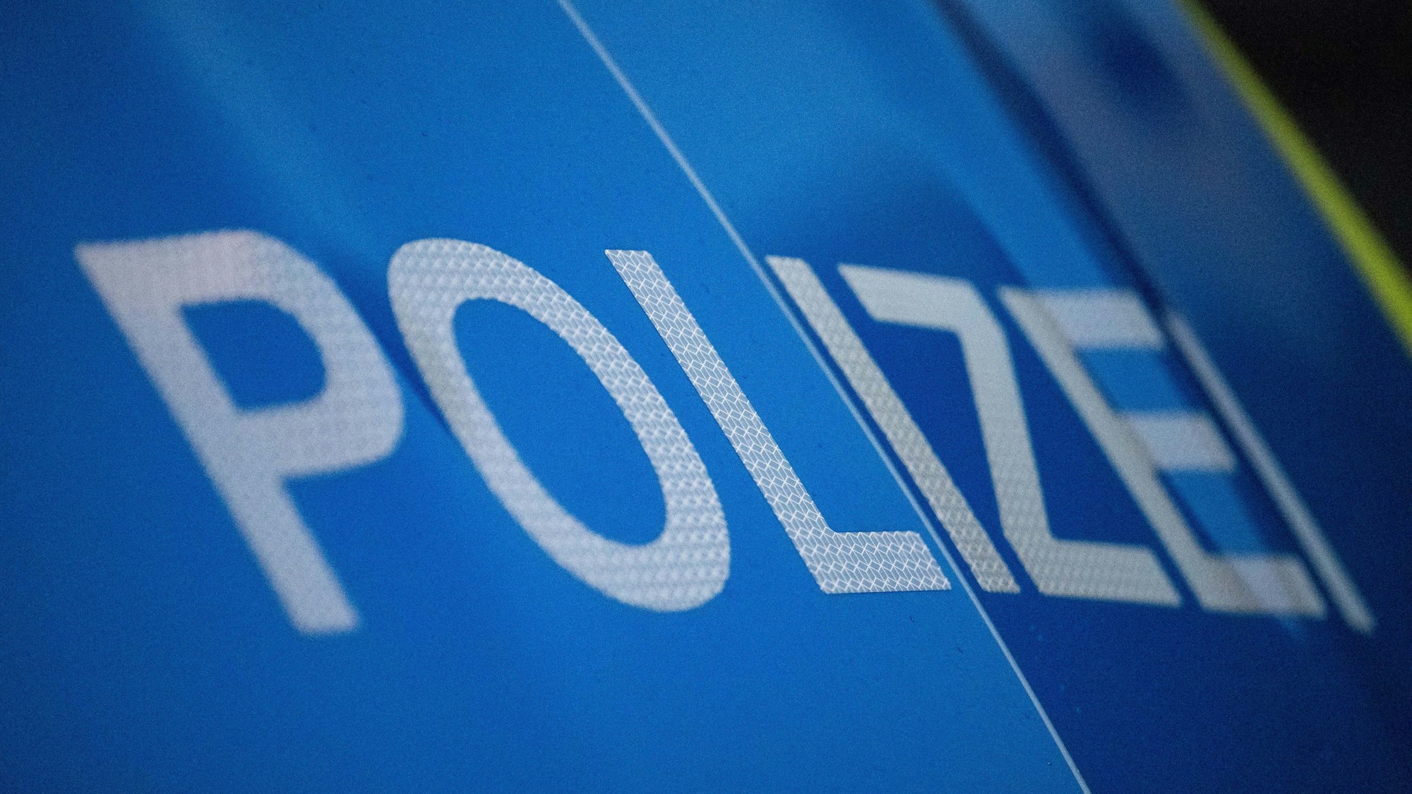 Das Foto zeigt den Schriftzug „Polizei“ auf einem Einsatzfahrzeug.