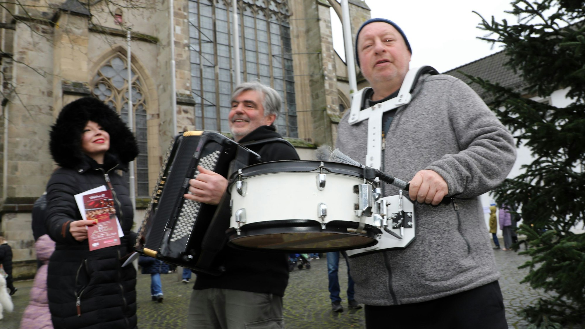 Musiker des Cirque Bouffon gehen musizierend über den Altenberger Adventsmarkt.