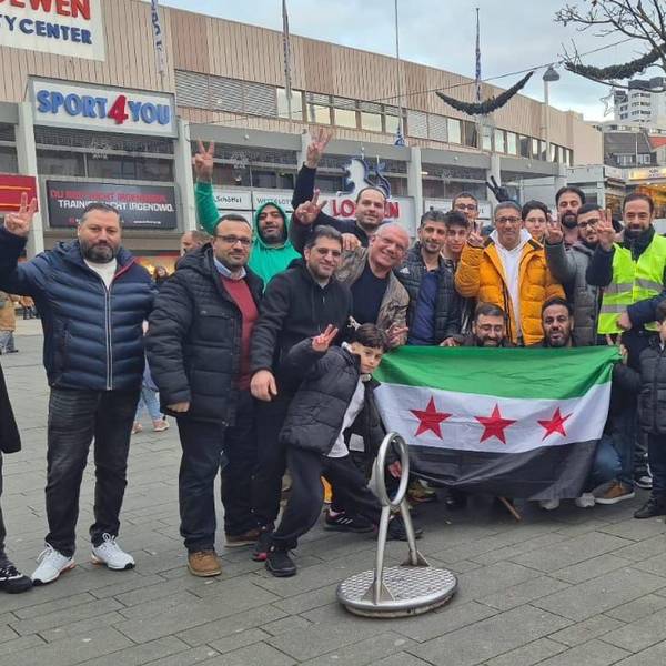 Syrer feiern in der Bergisch Gladbacher Innenstadt. Qutaibah Alkassat (rechts in der gelben Weste) feiert mit.