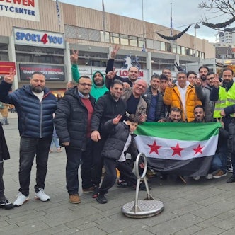Syrer feiern in der Bergisch Gladbacher Innenstadt. Qutaibah Alkassat (rechts in der gelben Weste) feiert mit.
