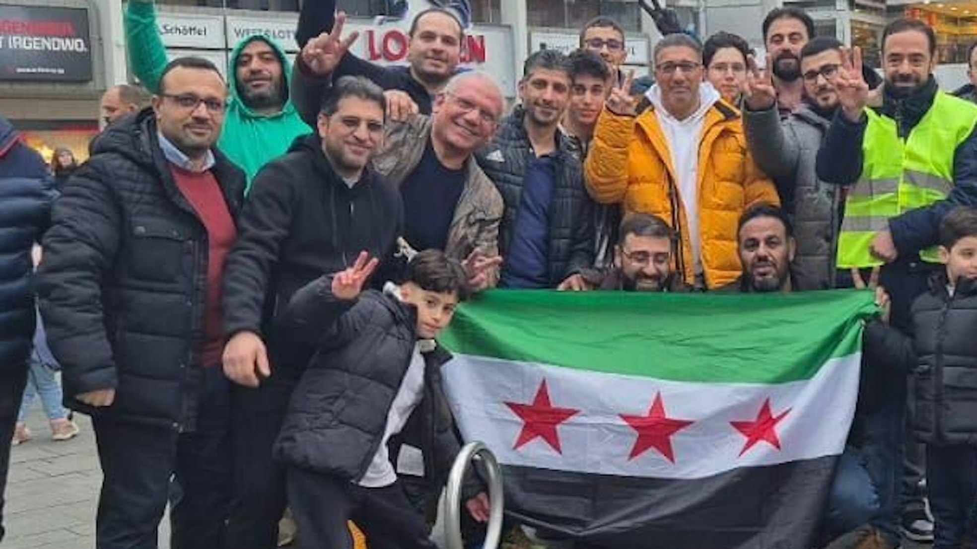 Syrer feiern in der Bergisch Gladbacher Innenstadt. Qutaibah Alkassat (rechts in der gelben Weste) feiert mit.