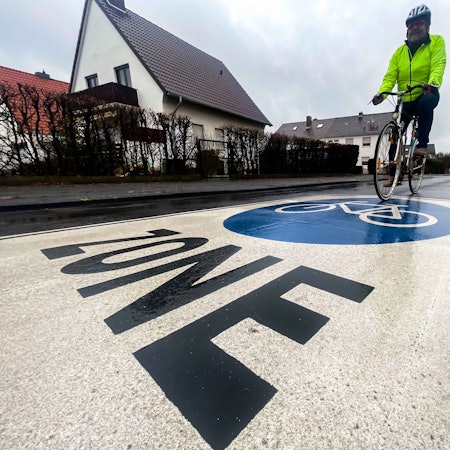 Ein Fahrradfahrer fährt über Fahrrad-Zone-Markierung.