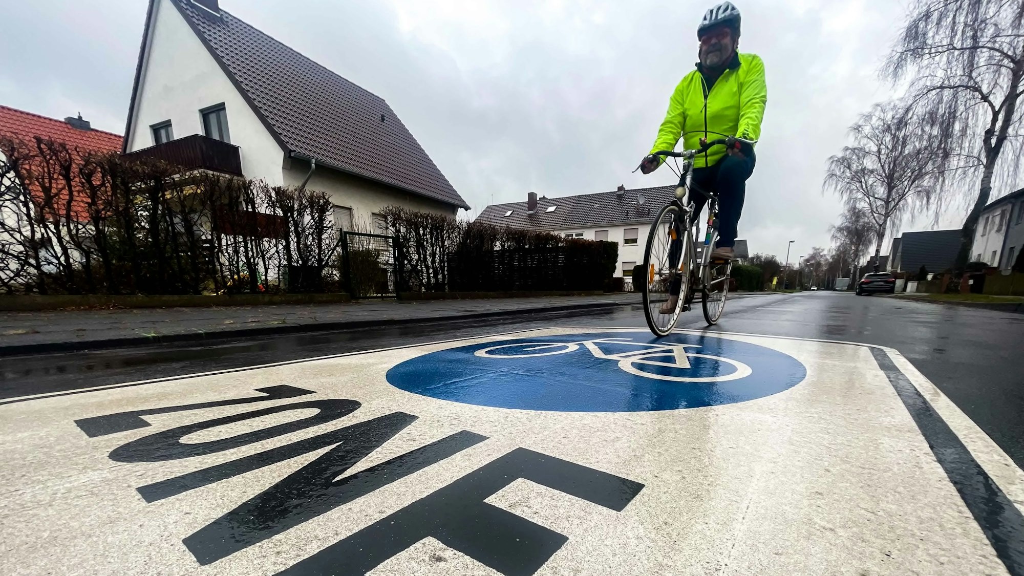 Ein Fahrradfahrer fährt über Fahrrad-Zone-Markierung.