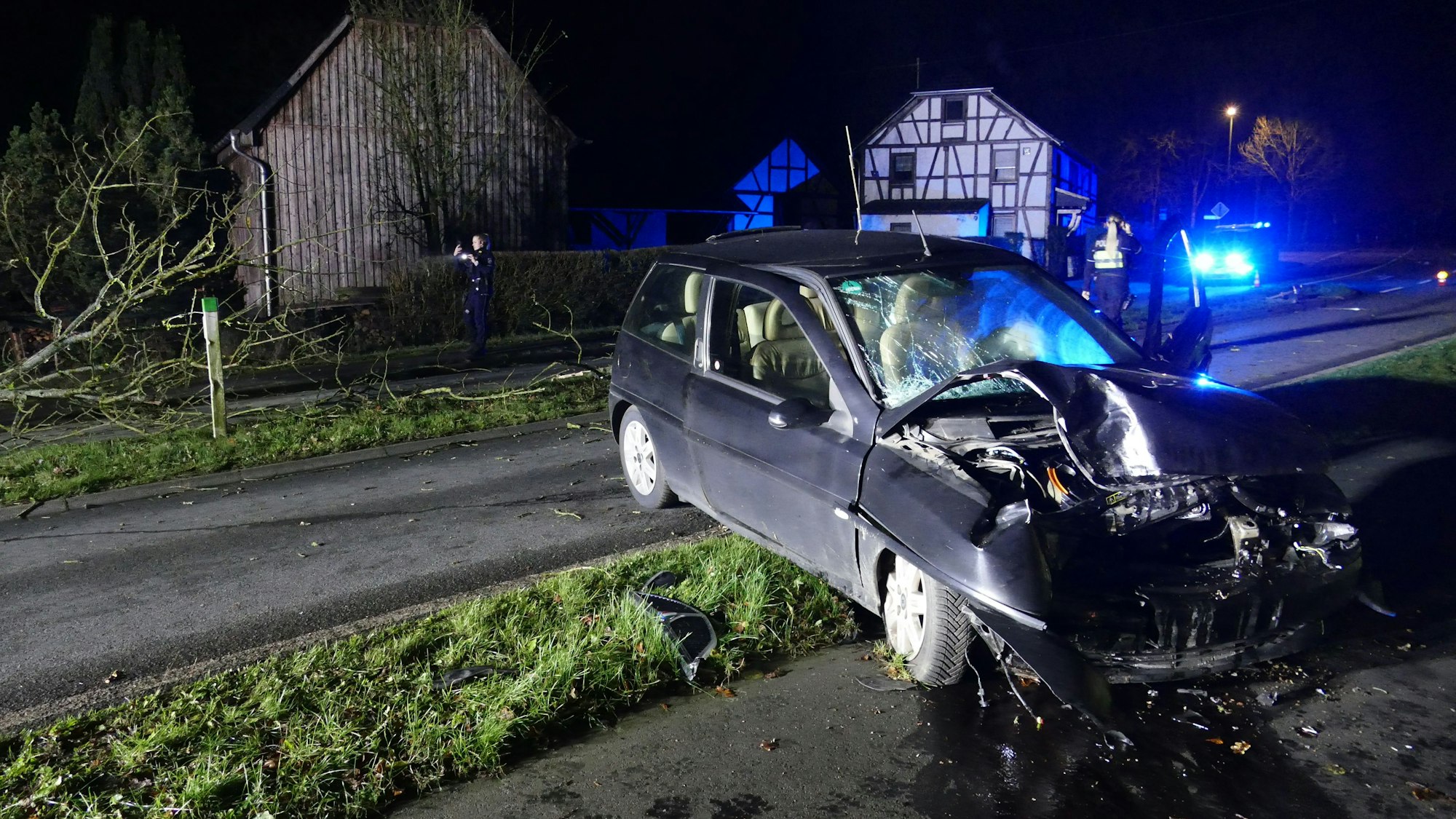 Ein beschädigtes Auto steht quer auf einer Straße.