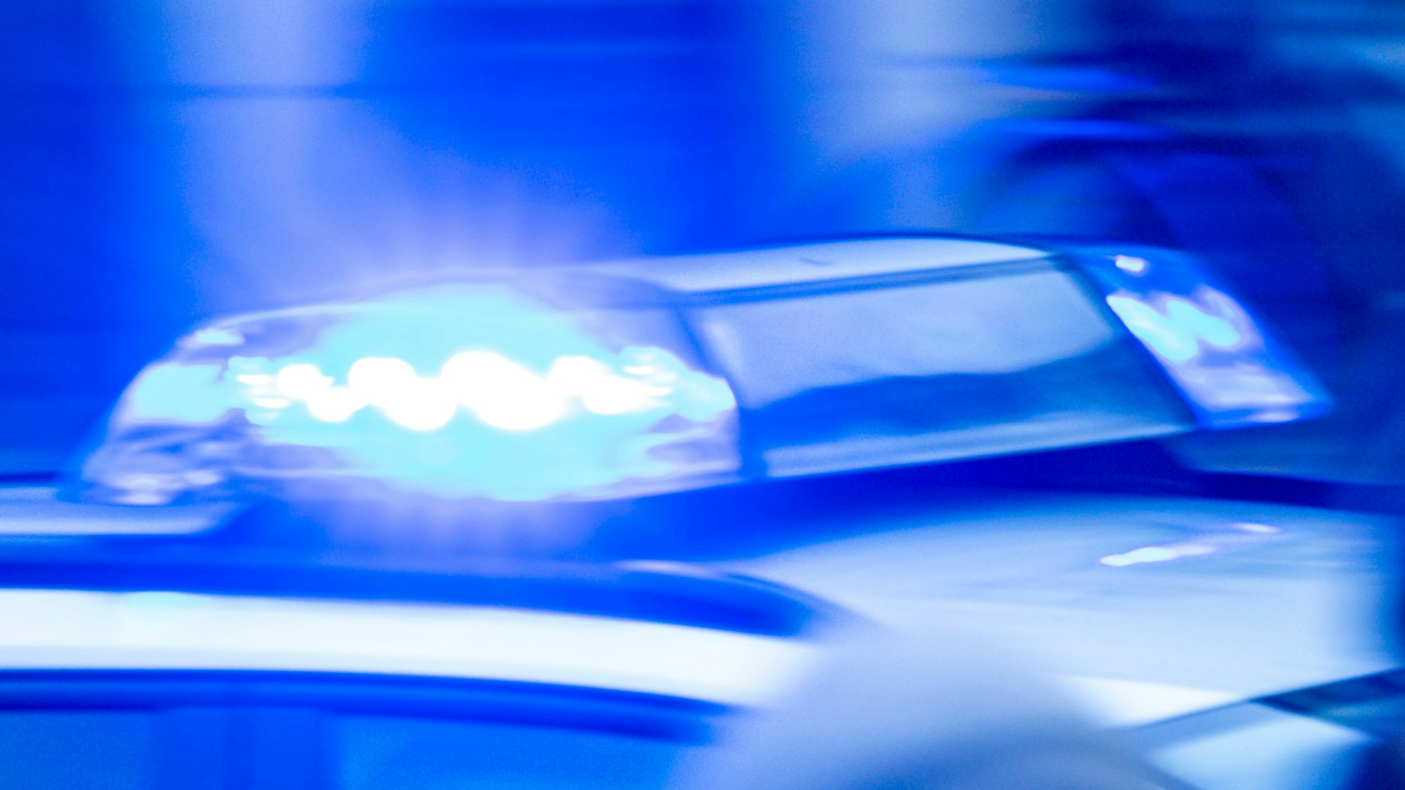 Ein Streifenwagen der Polizei ist mit Blaulicht im Einsatz.