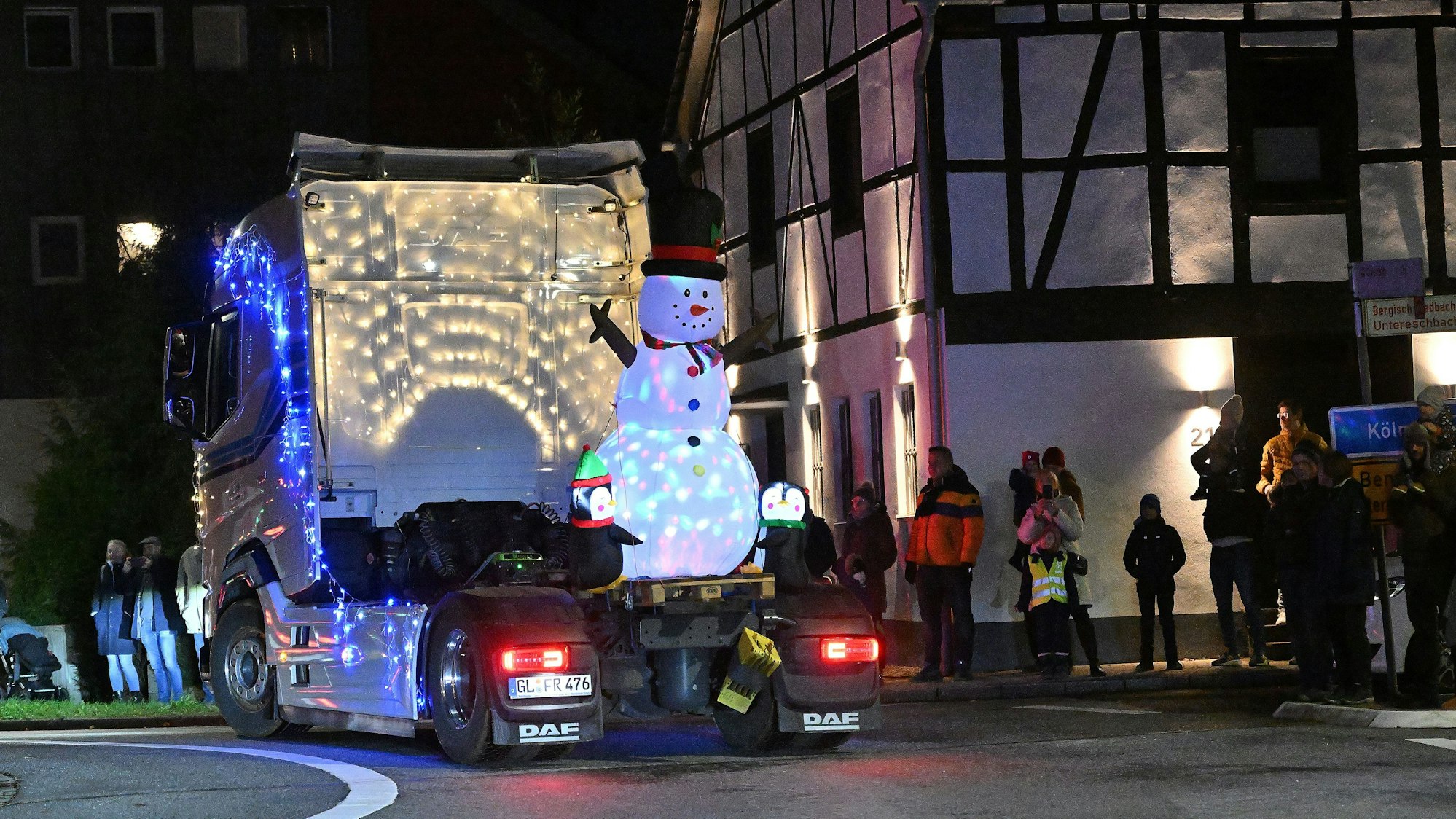 Eine Sattelzugmaschine mit aufblasbarem Schneemann fährt durch den Kreisverkehr in Overath-Heiligenhaus.